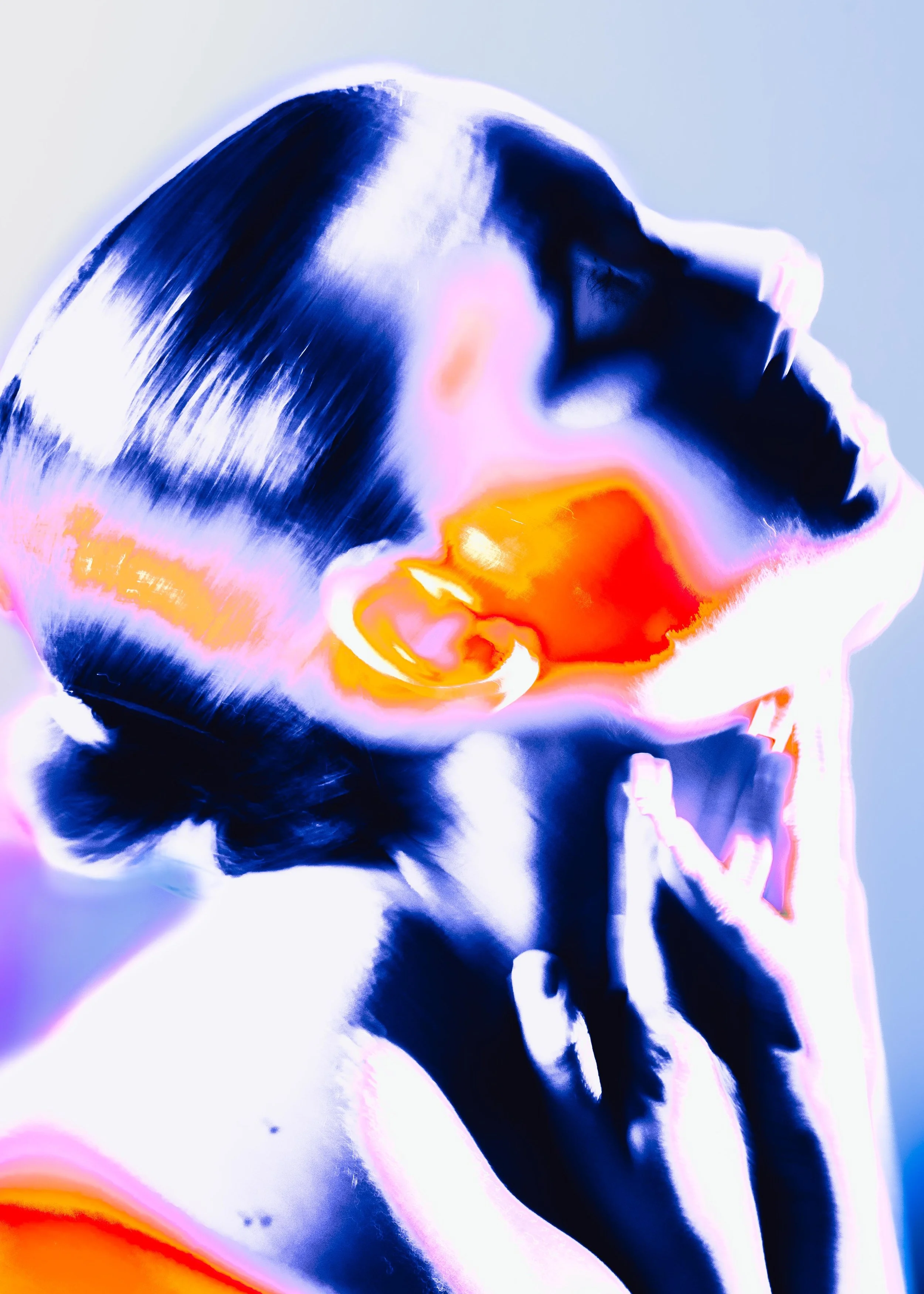 Close-up abstract image of a person’s face and hand, with intense color contrast and inverted colors, creating a surreal, artistic effect.