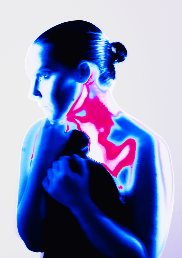A digital art image of a woman with a neon glow effect, holding her fists near her chest, with her hair tied back in a bun, and vibrant pink and blue lighting highlighting her neck and shoulders.