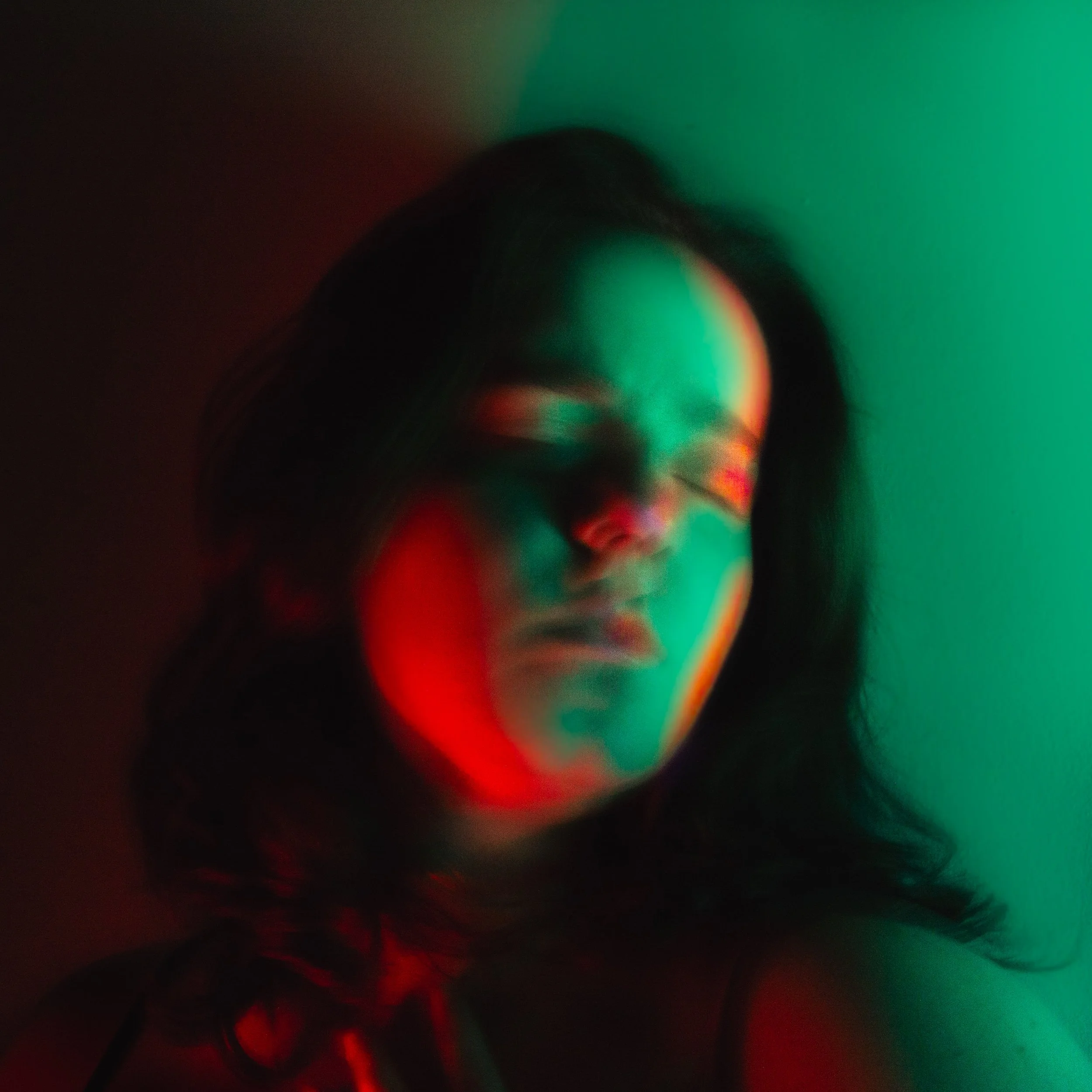 Abstract blurred image with streaks of green, red, and black colors.