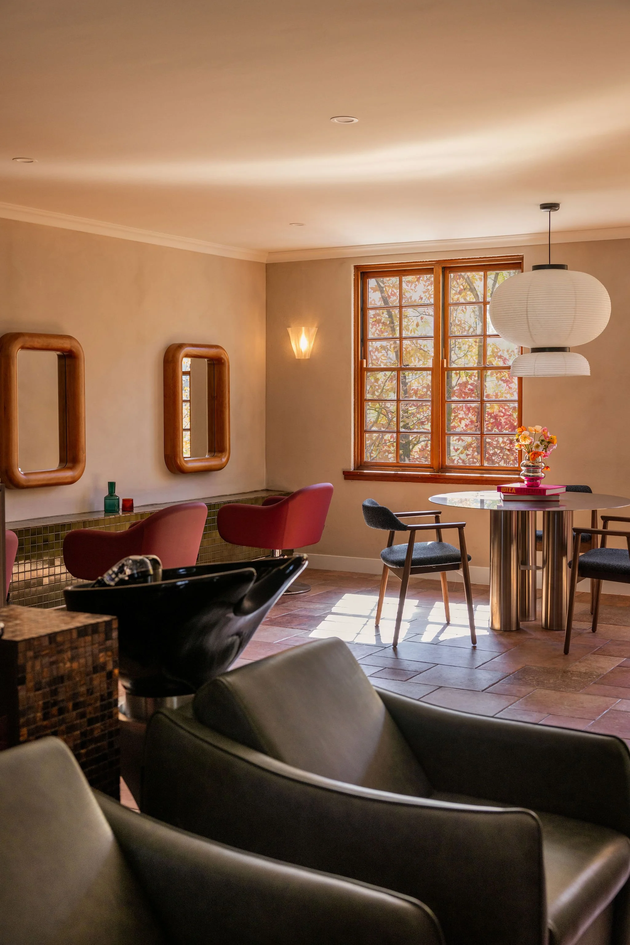 Salon Billy space with round table and pendant light.