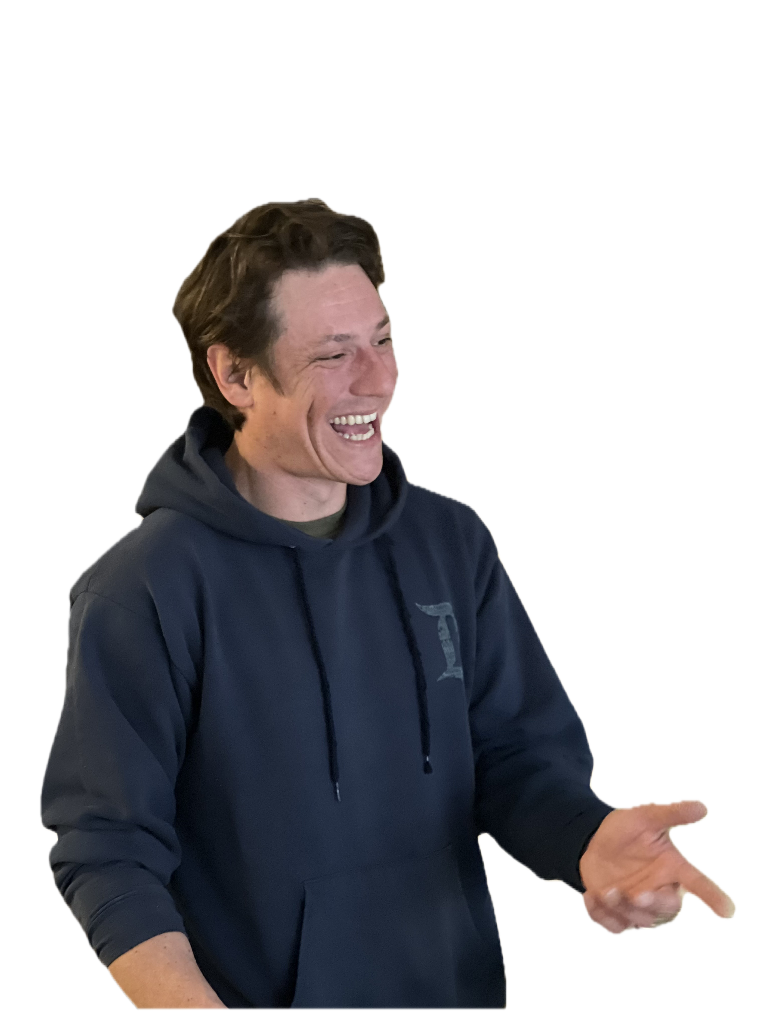 A young man with brown hair, wearing a navy blue hoodie, is smiling and gesturing with his hands. He appears to be talking or explaining something.
