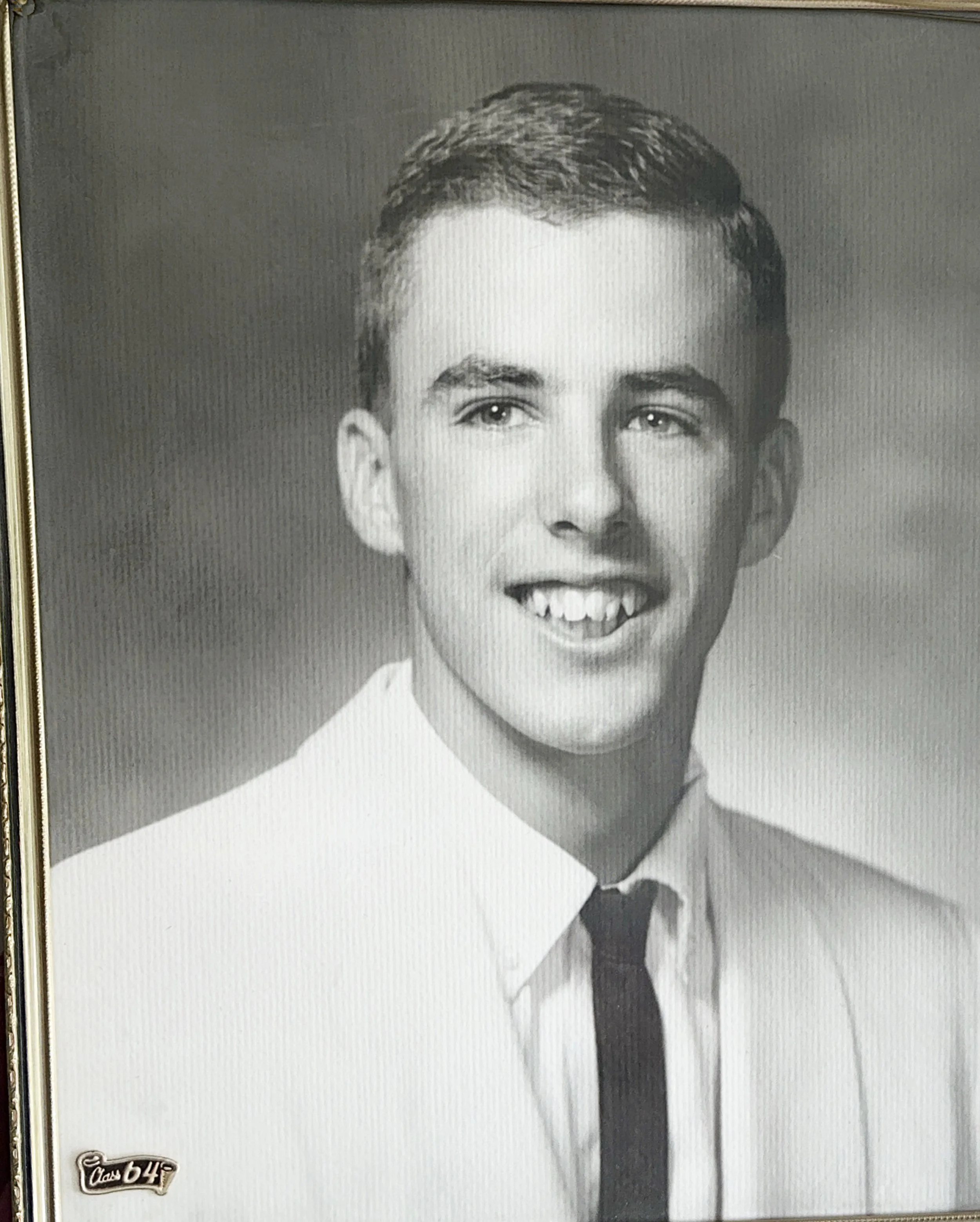 Black and white portrait of a smiling man in a suit and tie.