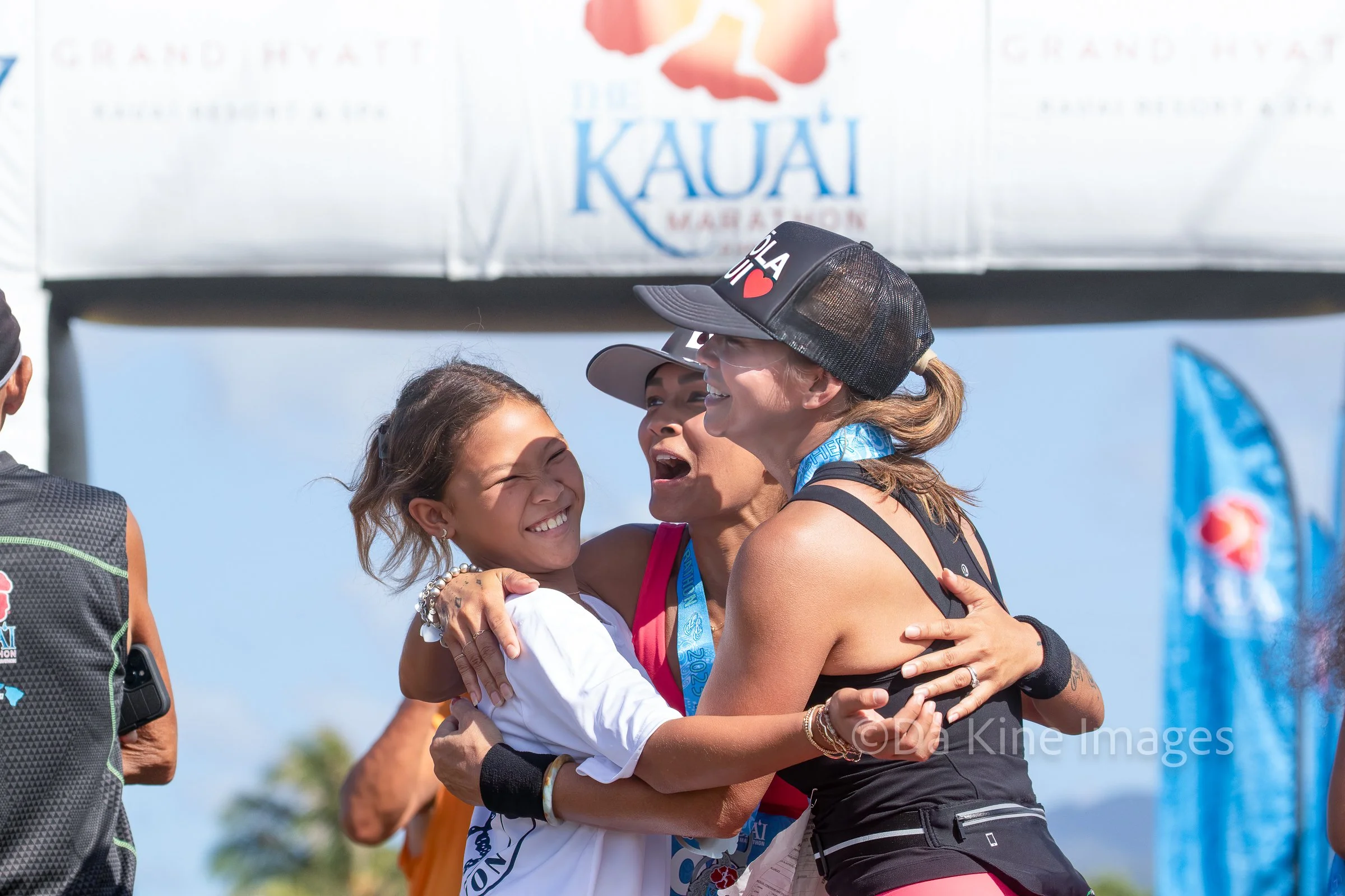 Runners celebrating at the finish line of the Kauai Marathon in Hawaii, reflecting the unforgettable race-day experiences and community spirit of destination marathon travel.