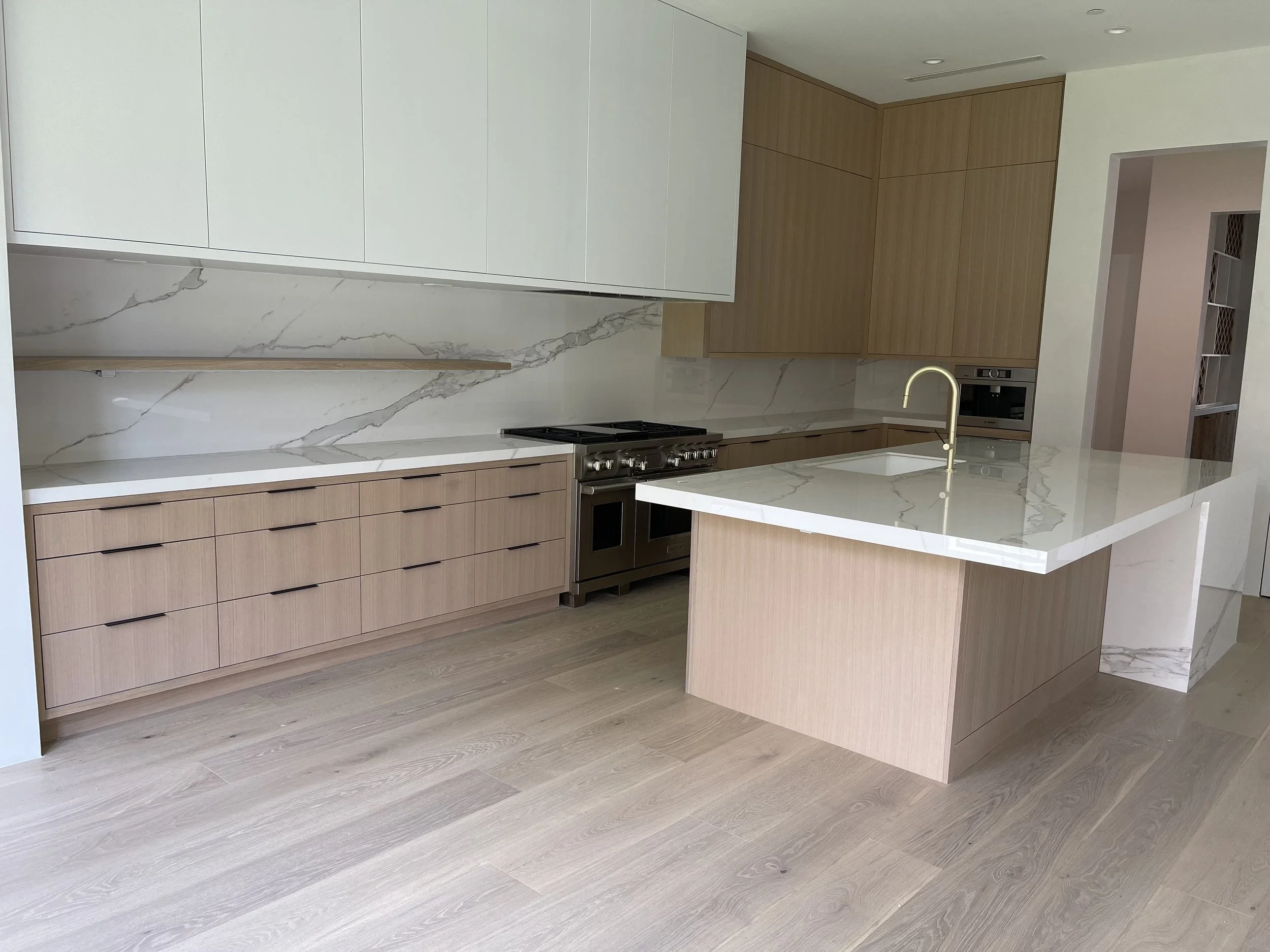 Contemporary kitchen with light stone countertops, two-tone cabinetry and wood flooring. Kitchen Countertops Houston, ‪713-568-5758‬