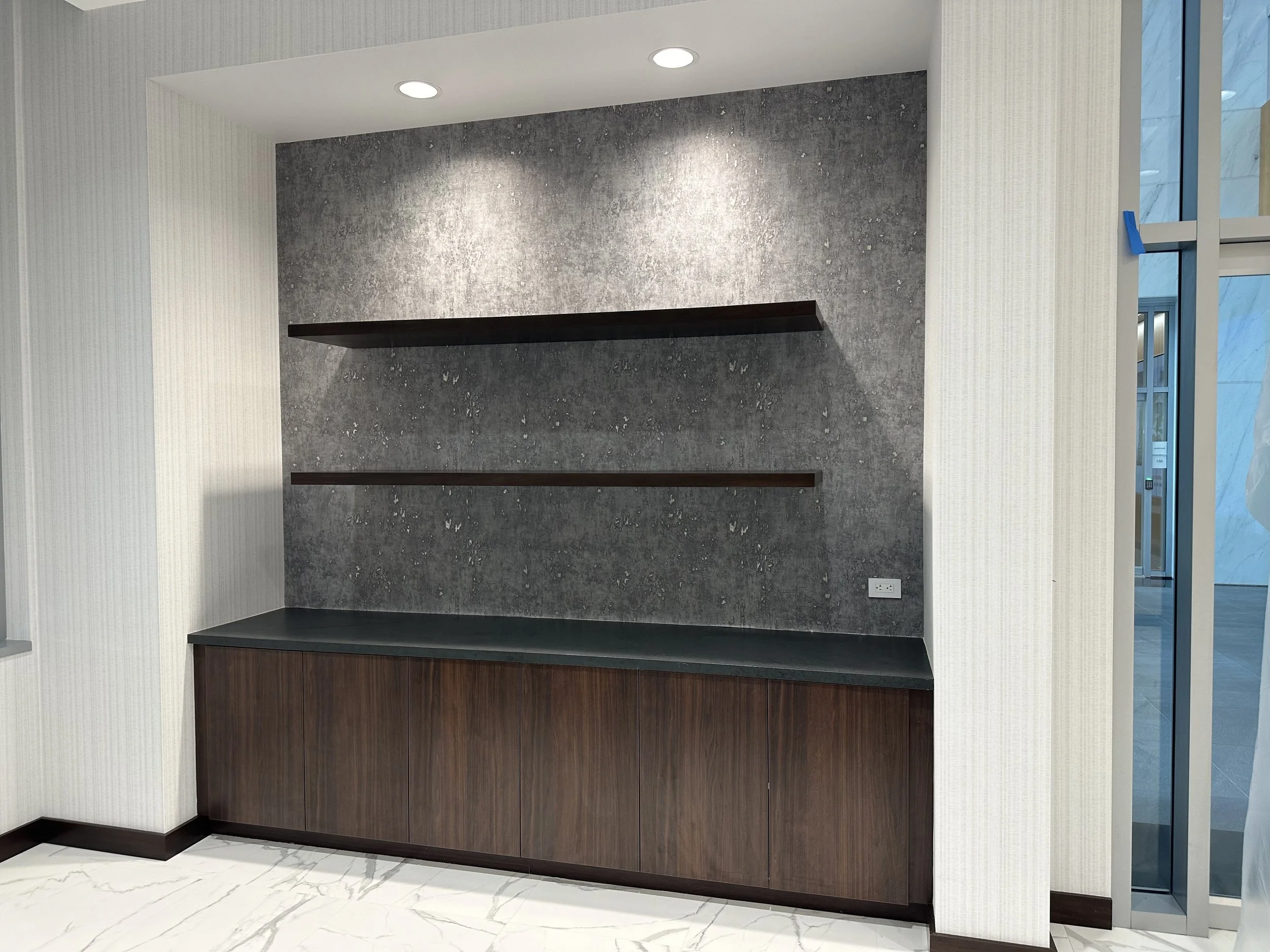 Built-in commercial service counter with dark stone surfaces and custom wood cabinetry in Houston, TX.