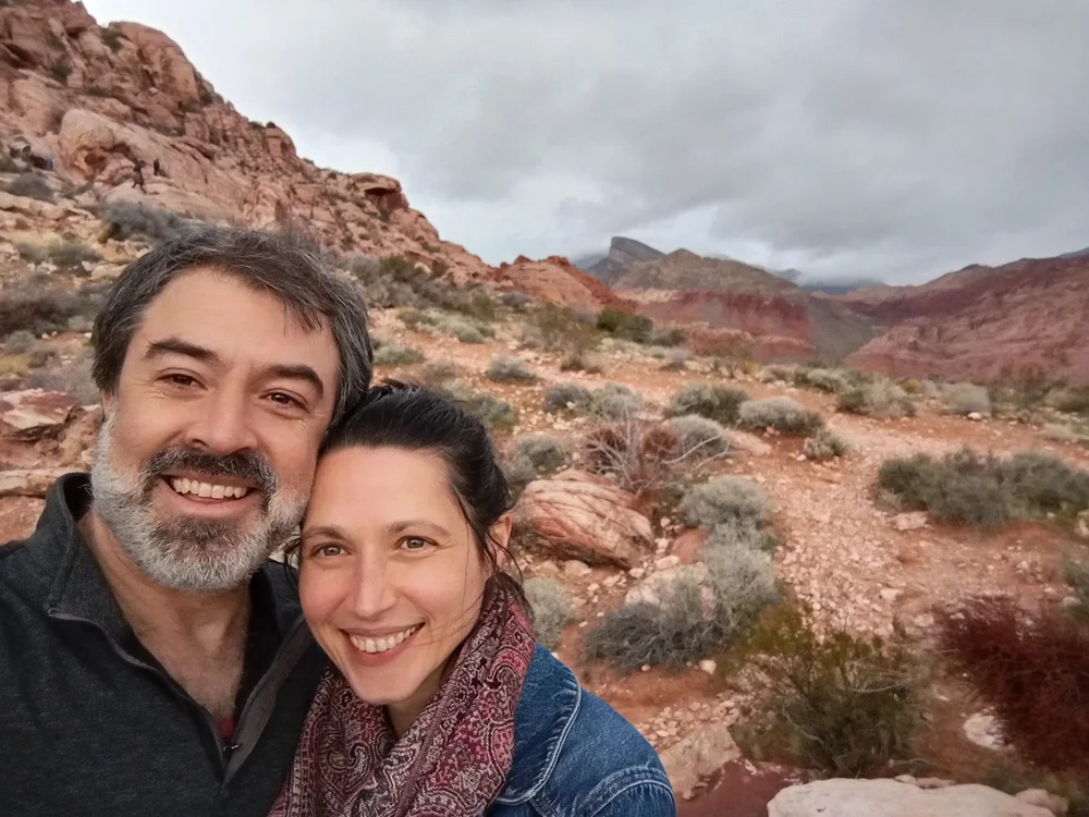 Massage Therapist Eric Fair-Layman and CranioSacral Therapist Erin Boyt smiling in front of a desert landscape.