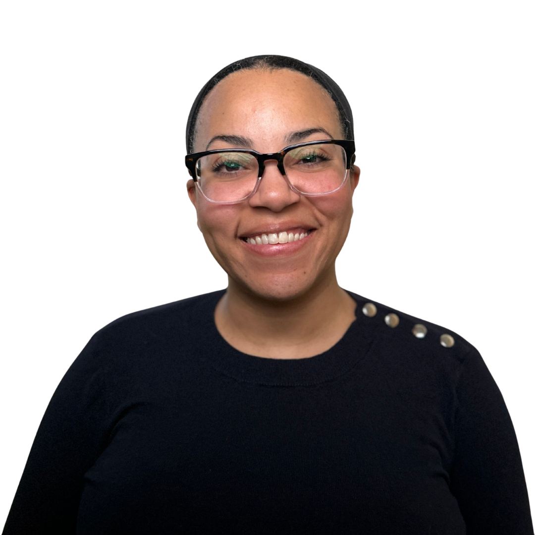 A medium complexion woman with glasses smiling wearing a blue sweater