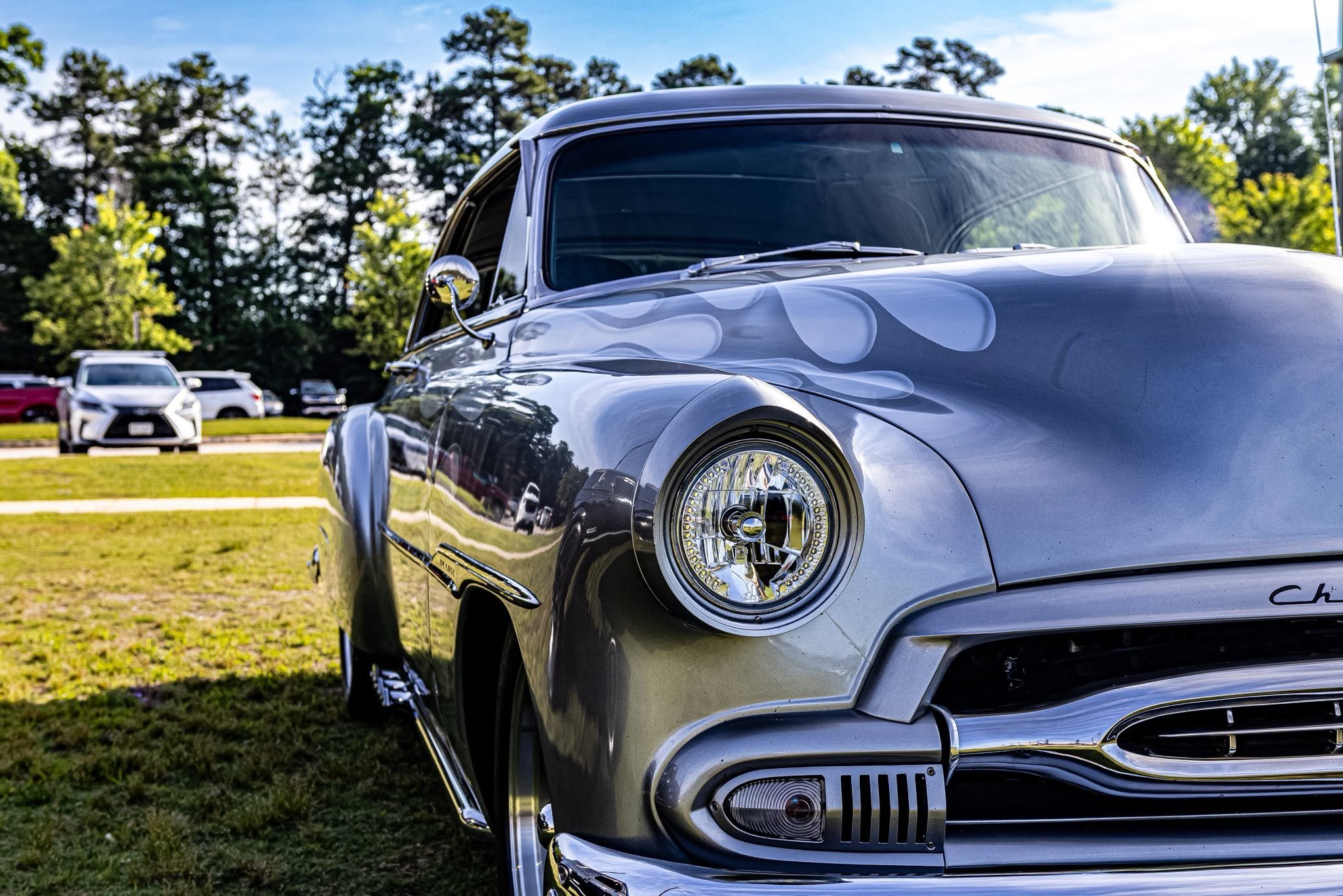 Up close and personal with pure American muscle. You can’t walk past this silver finish and those classic flames without stopping to stare. This is exactly what car show season is all about: great rides, good vibes, and acres of horsepower.