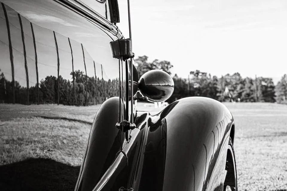 Up close and personal with a true classic. There’s something timeless about the curve of this fender, and the history reflected in the glass. Just a vintage beauty resting out in the open air, exactly where she belongs.