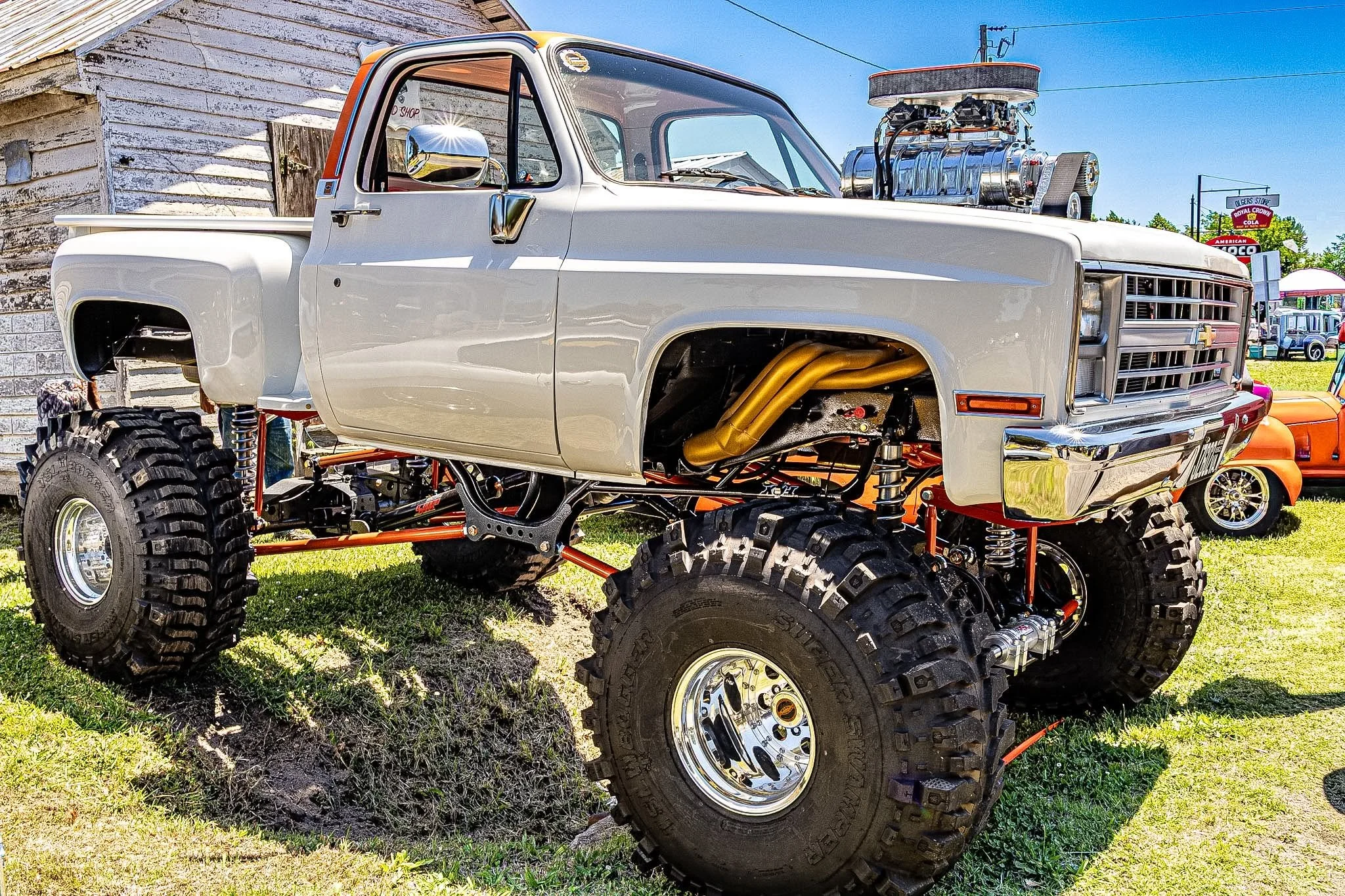 Old-school soul meets modern muscle. This white Chevy truck reimagined for the dirt—sitting high on a lifted suspension, rocking massive tires, and packing a supercharged punch under the hood. There’s nothing quite like seeing it parked over a ditch,