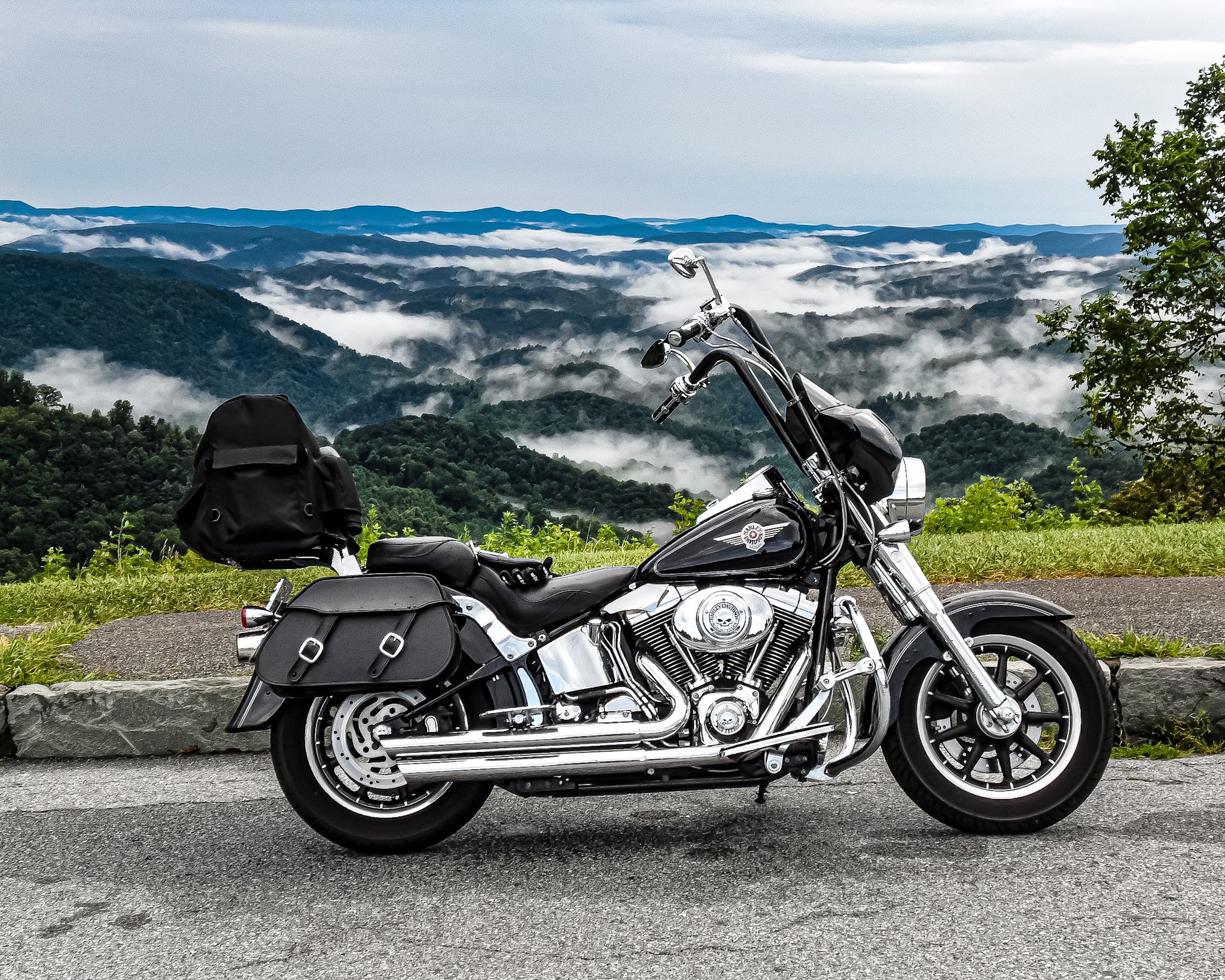 Caught a perfect moment on a ride a few years ago on the Blue Ridge Parkway. There’s my Harley, all black and gleaming chrome, parked right at the edge of the mountain. In the background, the mountains are doing their thing—dense green forests stretc