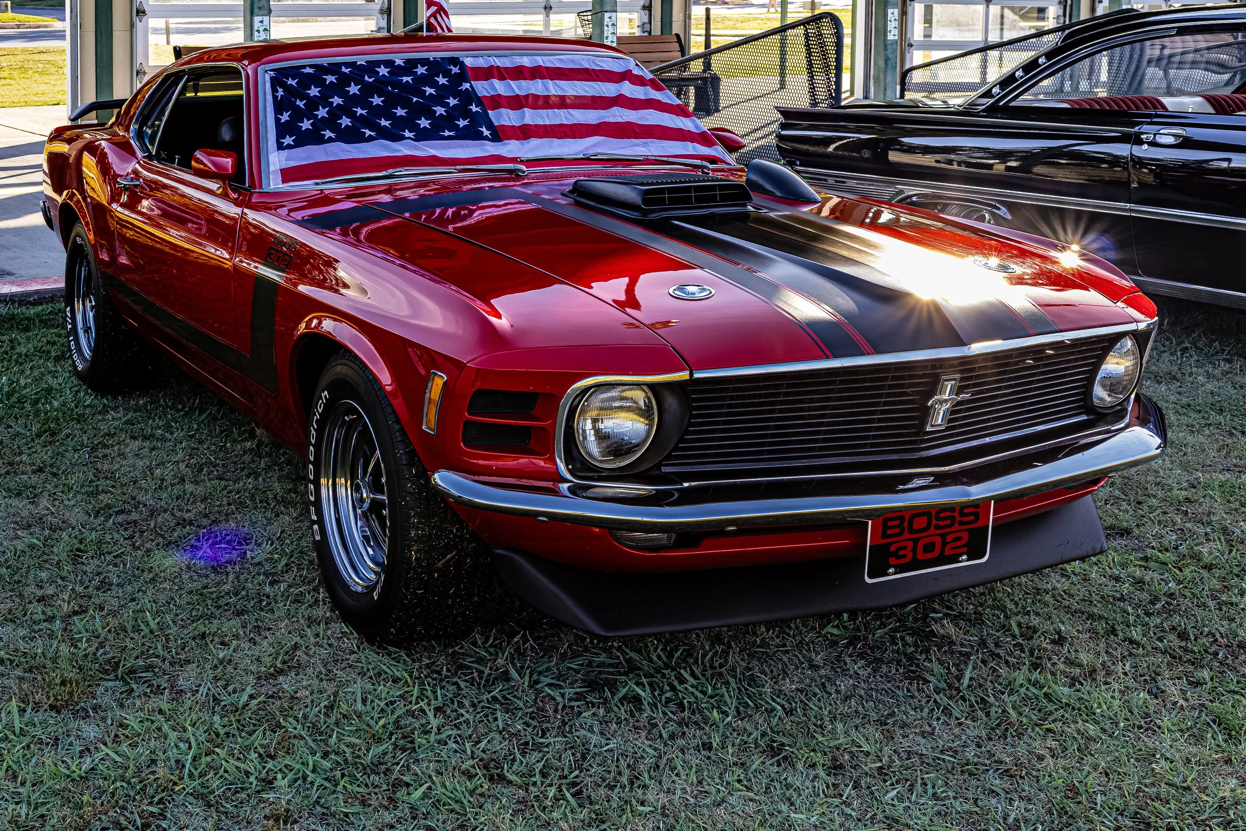 There’s nothing quite like catching sight of a classic. Caught this stunning red vintage Shelby Boss 302 —those bold black racing stripes are timeless, but it was the American flag draped proudly over the windshield that really stole the show.