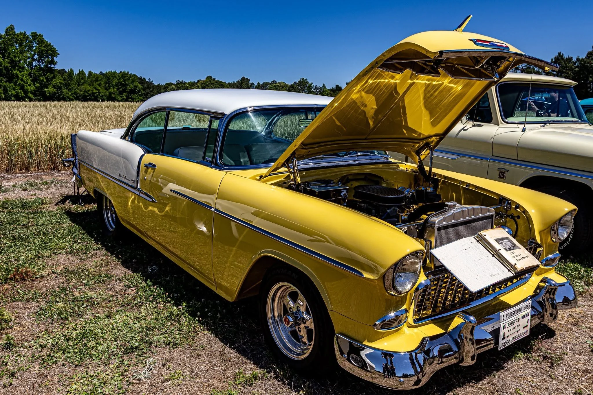 You know those perfect summer days where everything just aligns? I spotted this stunning yellow ride parked right on the grass, hood up and ready for everyone to admire all her beauty. 