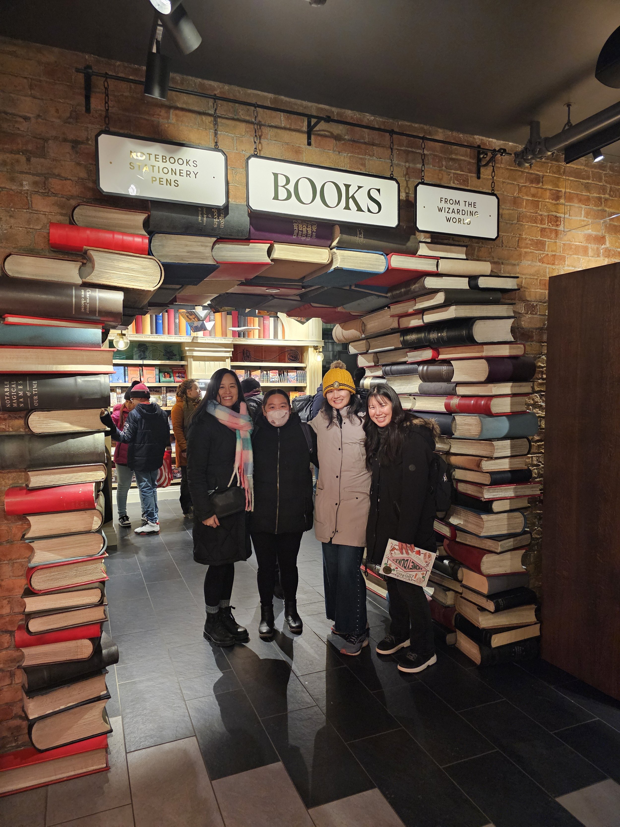 Dr. Cassie Lopez-Jeng and her best friends standing in a archway of books.