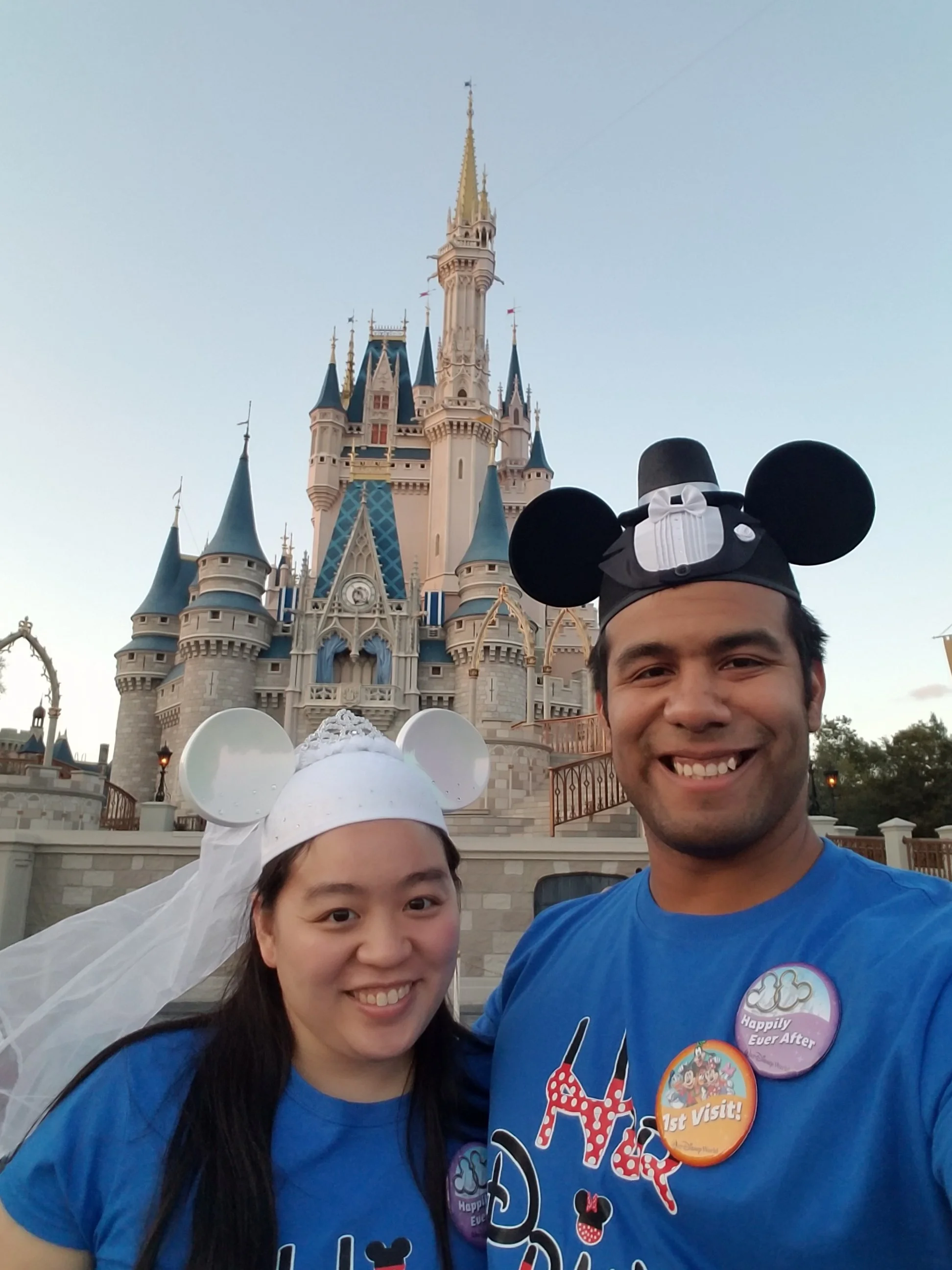 Dr. Cassie Lopez-Jeng with her spouse at Disney World wearing wedding-themed Mickey ears.