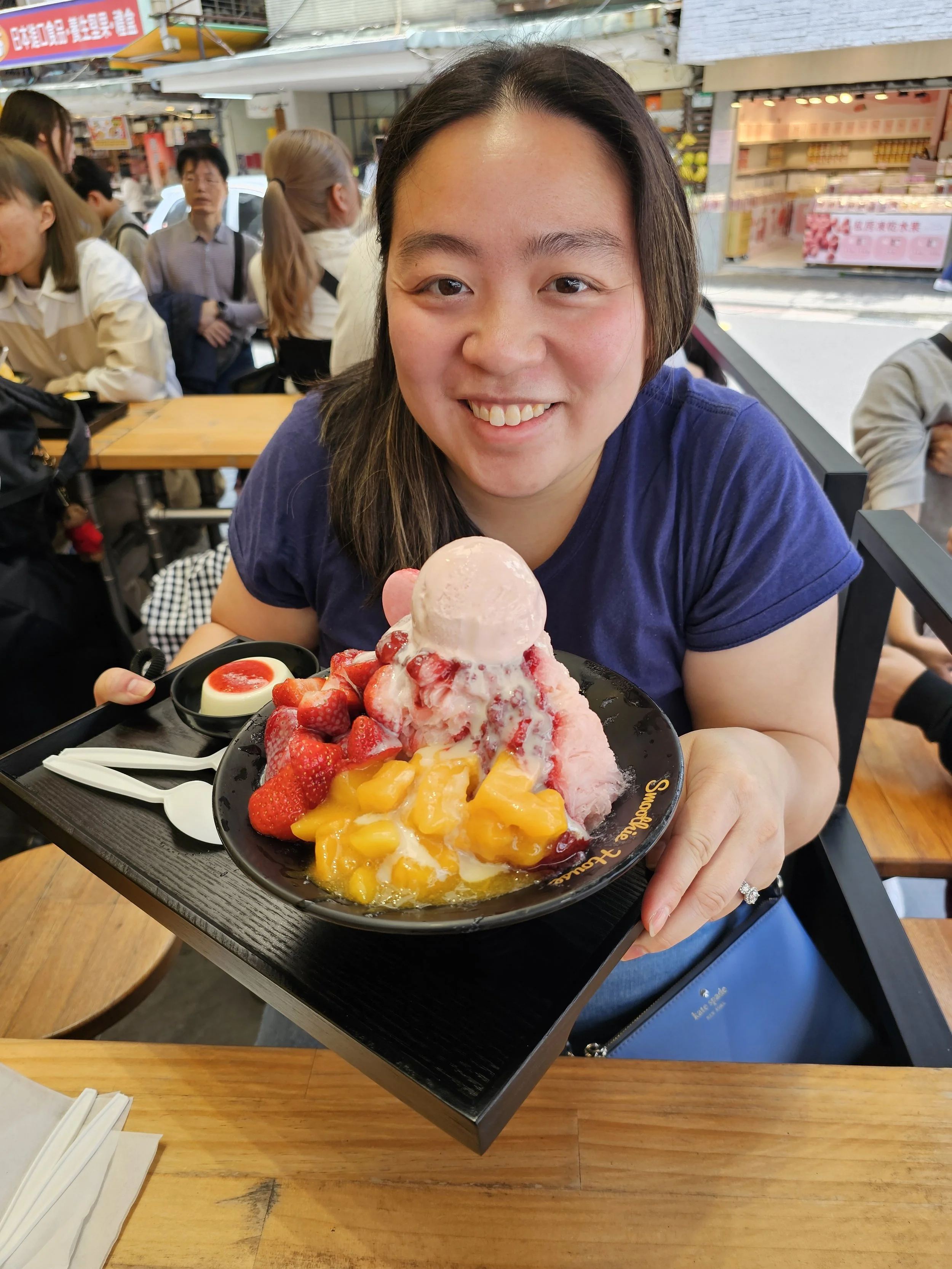 Dr. Cassie Lopez-Jeng smiling holding a bowl of shaved ice with fruit on it.