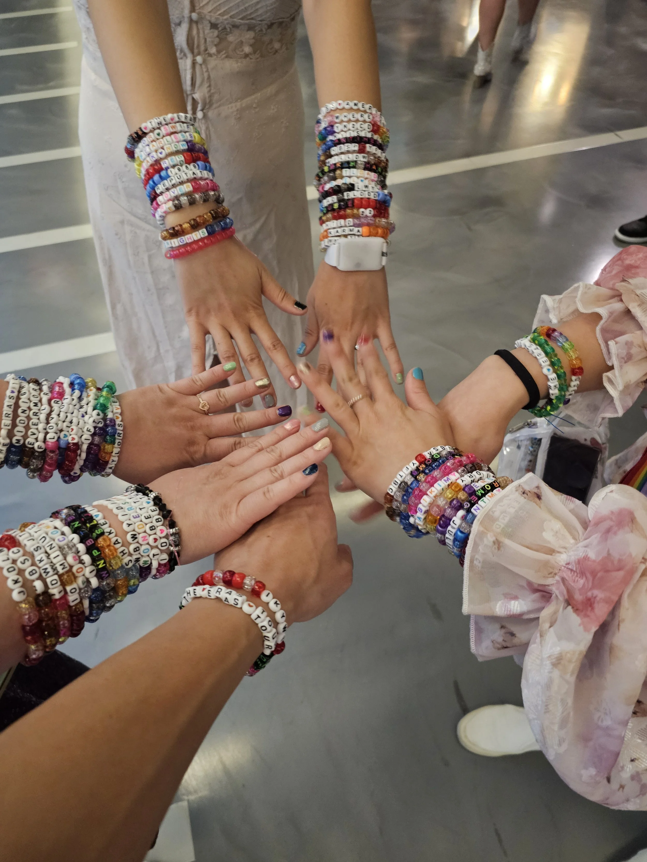 Dr. Cassie Lopez-Jeng and her friends wearing friendship bracelets at Taylor Swift's Eras Tour concert.