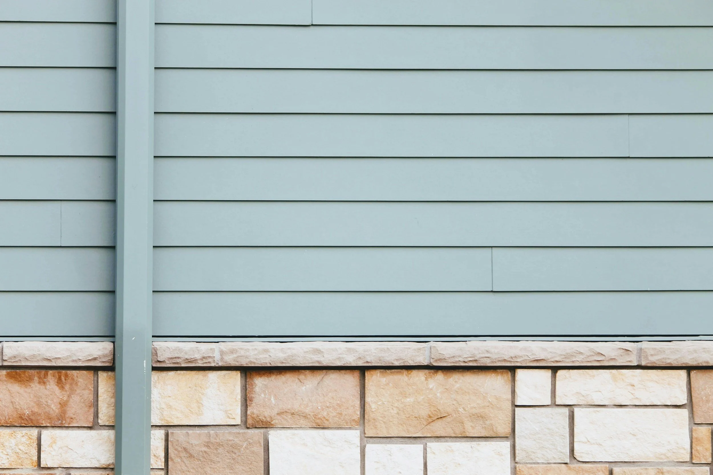 Light gray horizontal siding with brick exterior accents