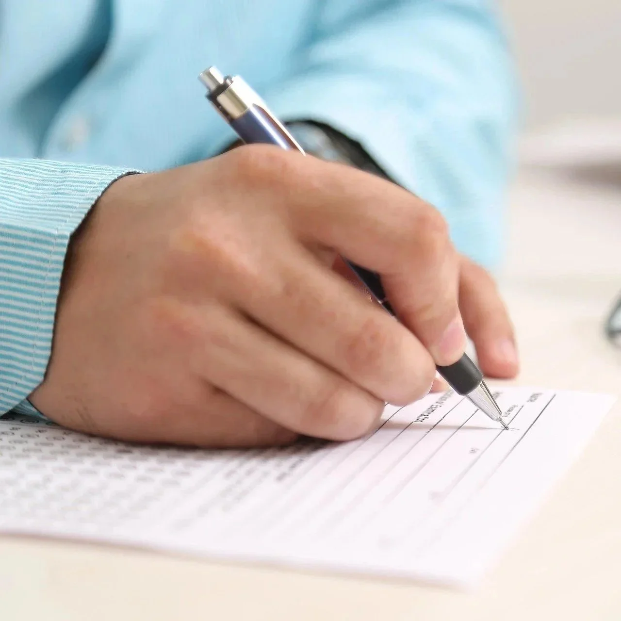 Person writing on a form