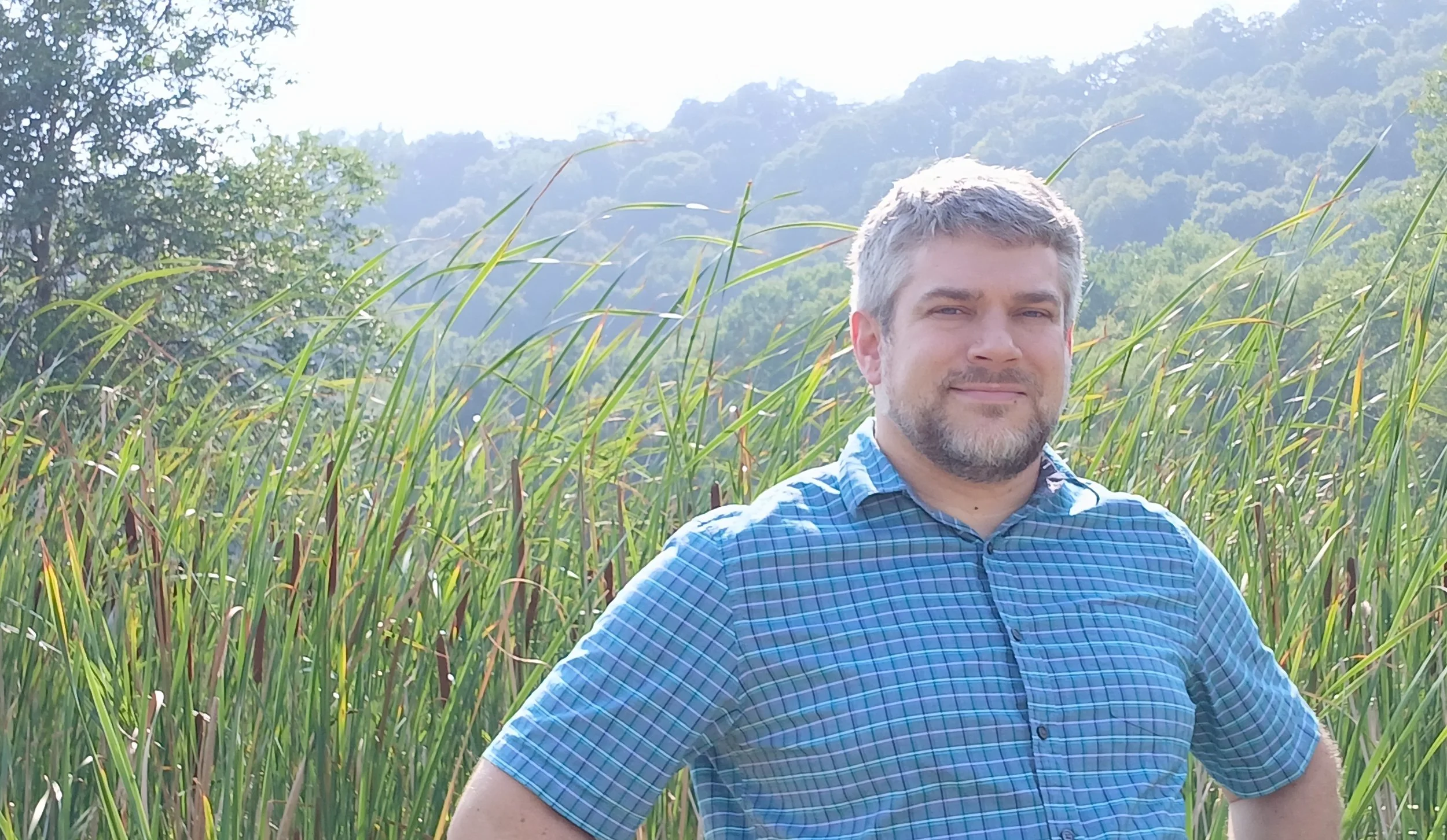 Benton standing in front of cattails at Spring Lake Park in North Mankato