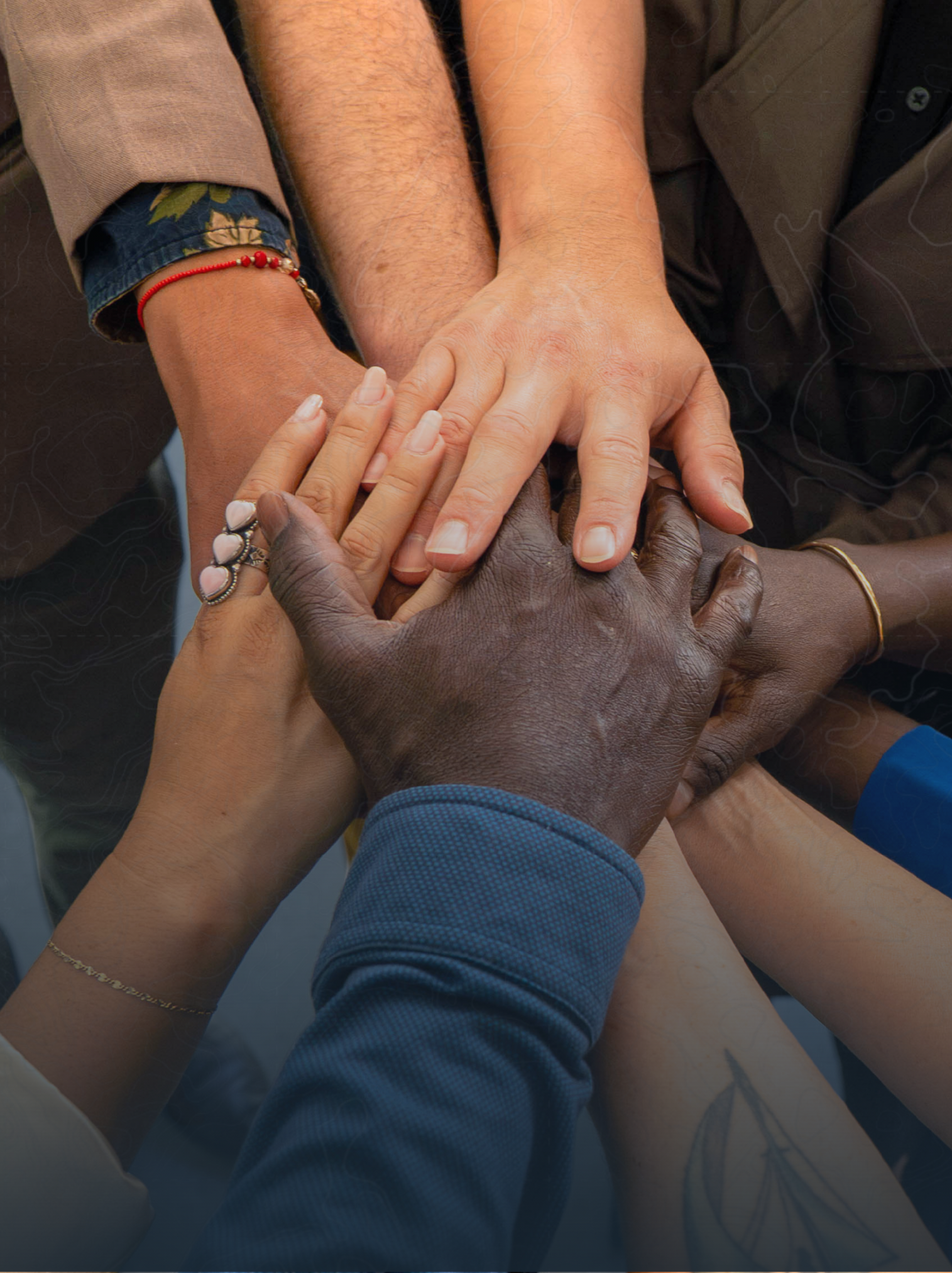 Close-up of diverse hands stacked together, symbolizing unity or teamwork.