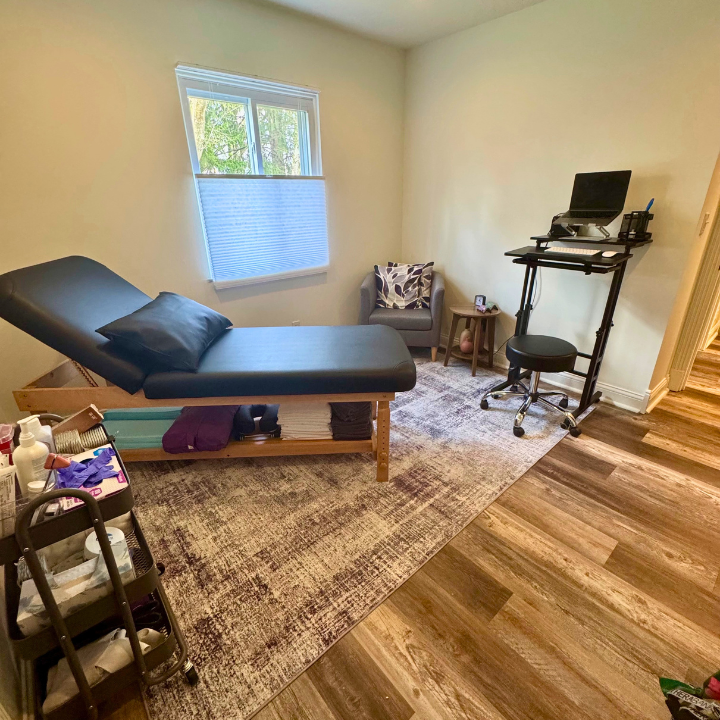 Room with a treatment table covered in black vinyl and a pillow, positioned next to a window with partial blinds. Unbound Pelvis is located at 271 S. Liberty Street Powell, OH 43065