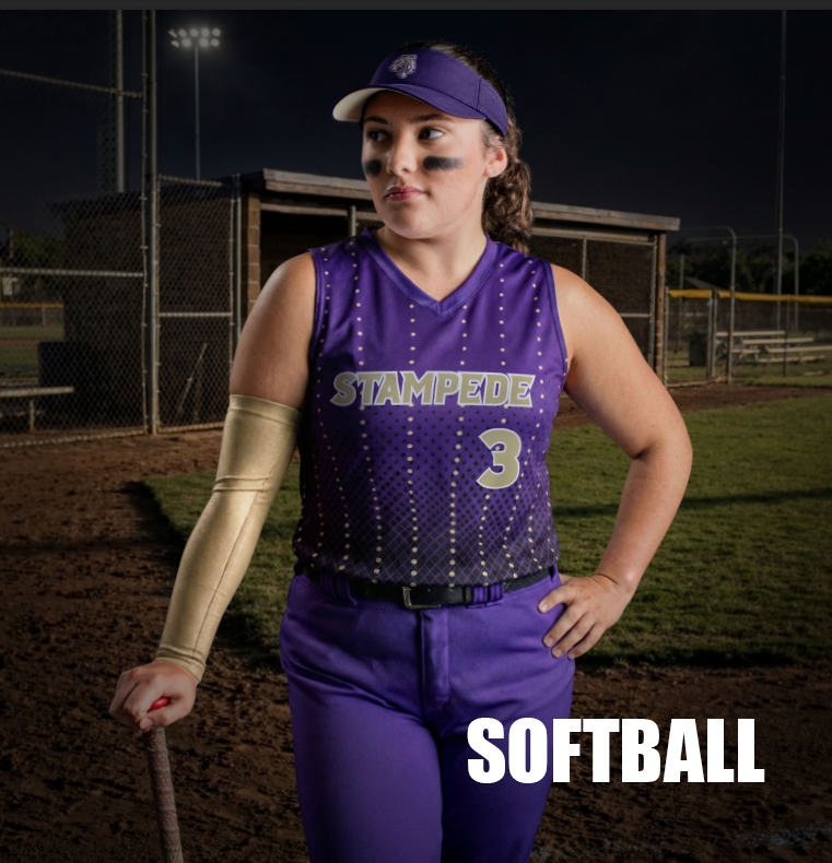 A female softball player in purple uniform with the number 3 and 'STAMPEDE' on her jersey, standing on a softball field at night, with eye black under her eyes and a visor on her head.