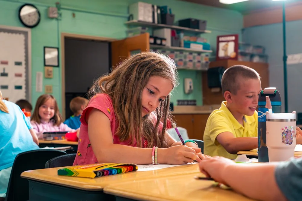 Elementary school classroom with young students working at their desks.