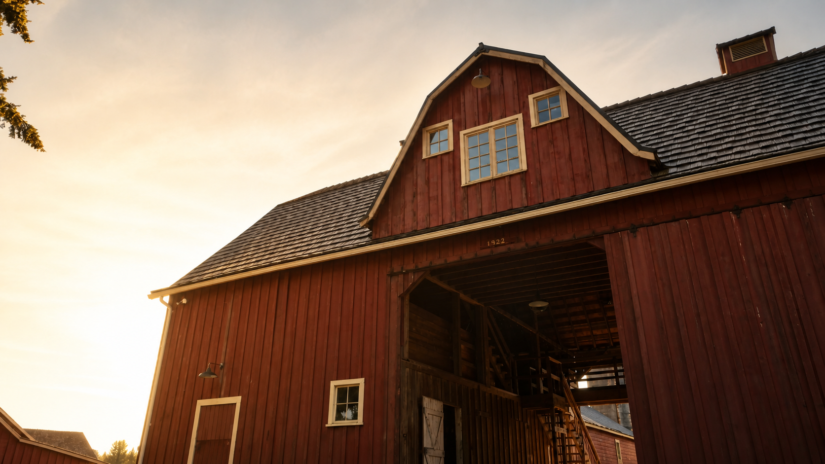 Warm sunset view of the historic red barn at The Kent Farm.