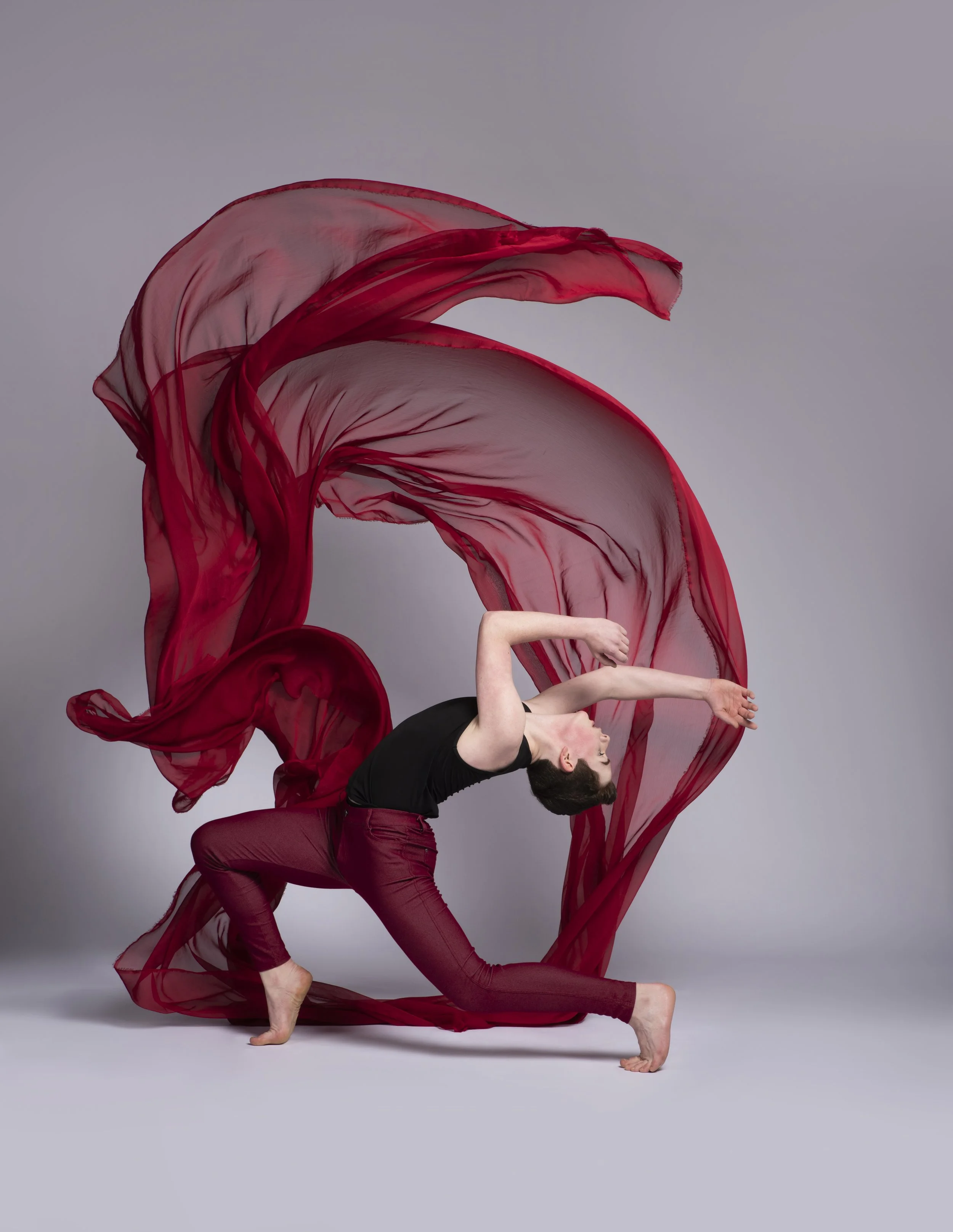 Dance photo of Burke Brickner, framed by a bold, red silk in the background. (Photo by Cody Green with Code Art Photography)