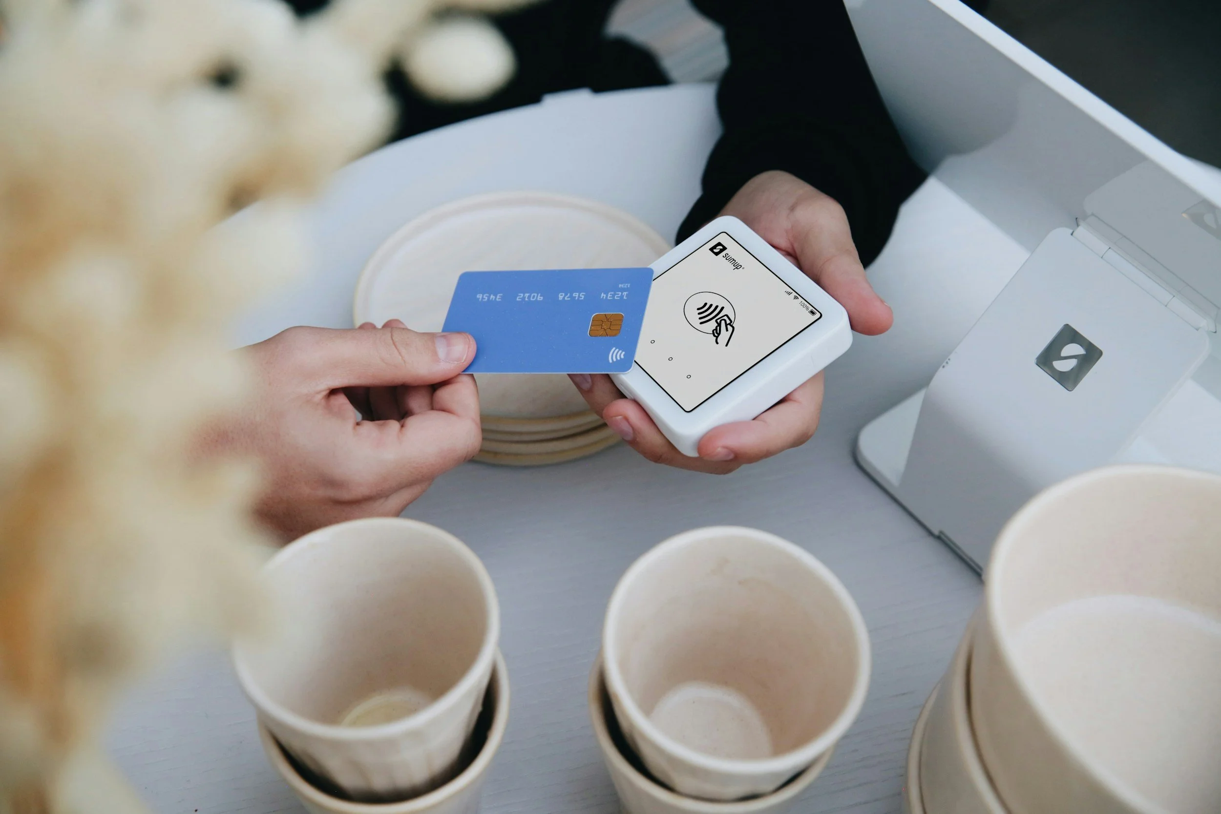 A person holding a digital payment device and a credit card.