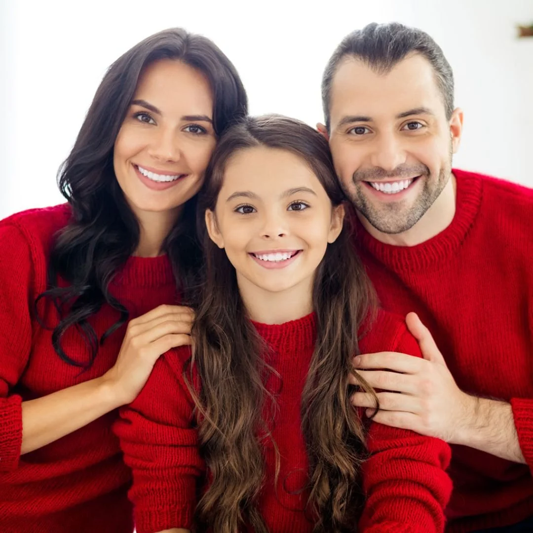 Family of three smiling.