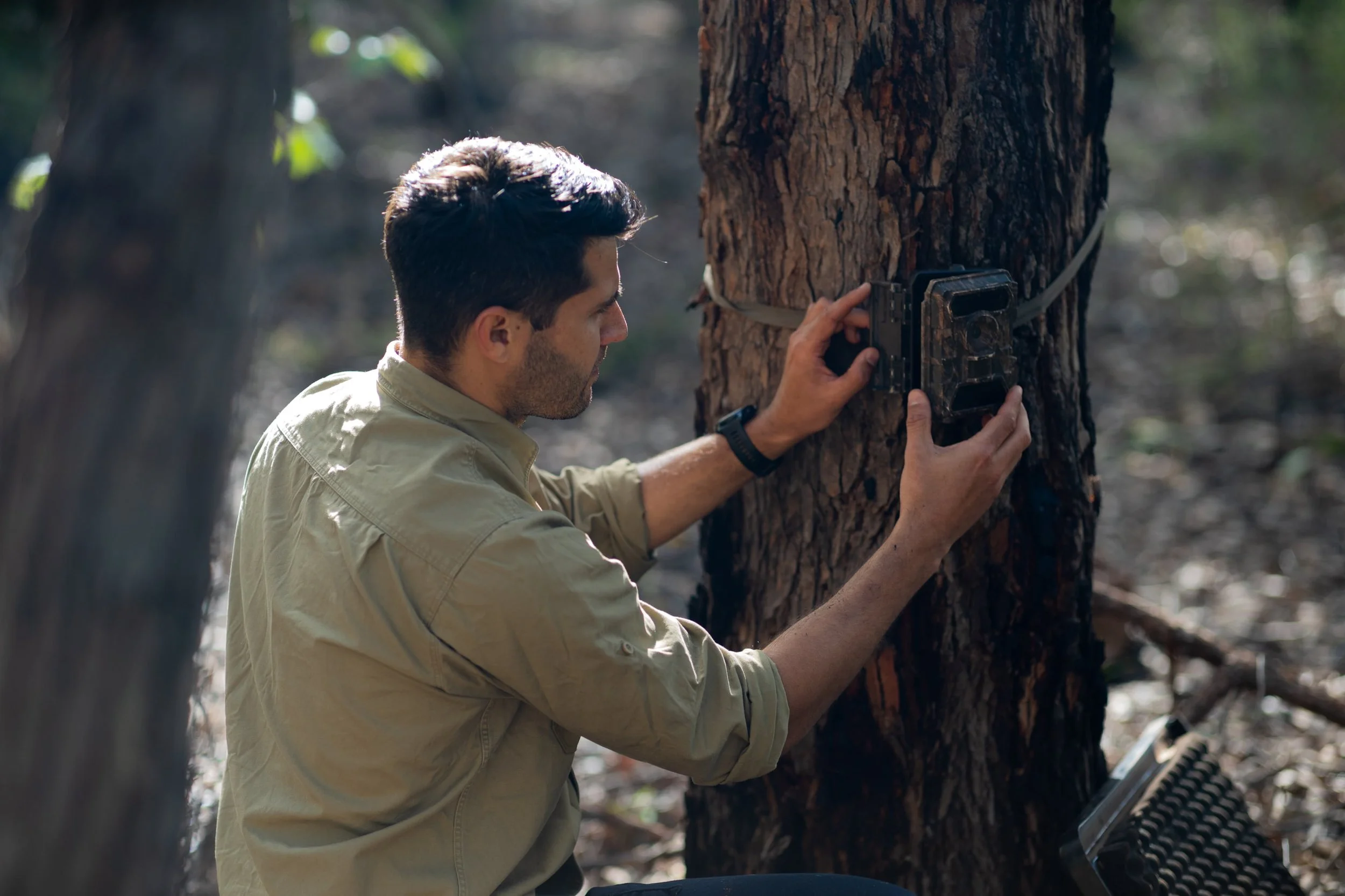 Environmental surveyor Chris Knuckey in a beige shirt running tests and screening in Australian environment