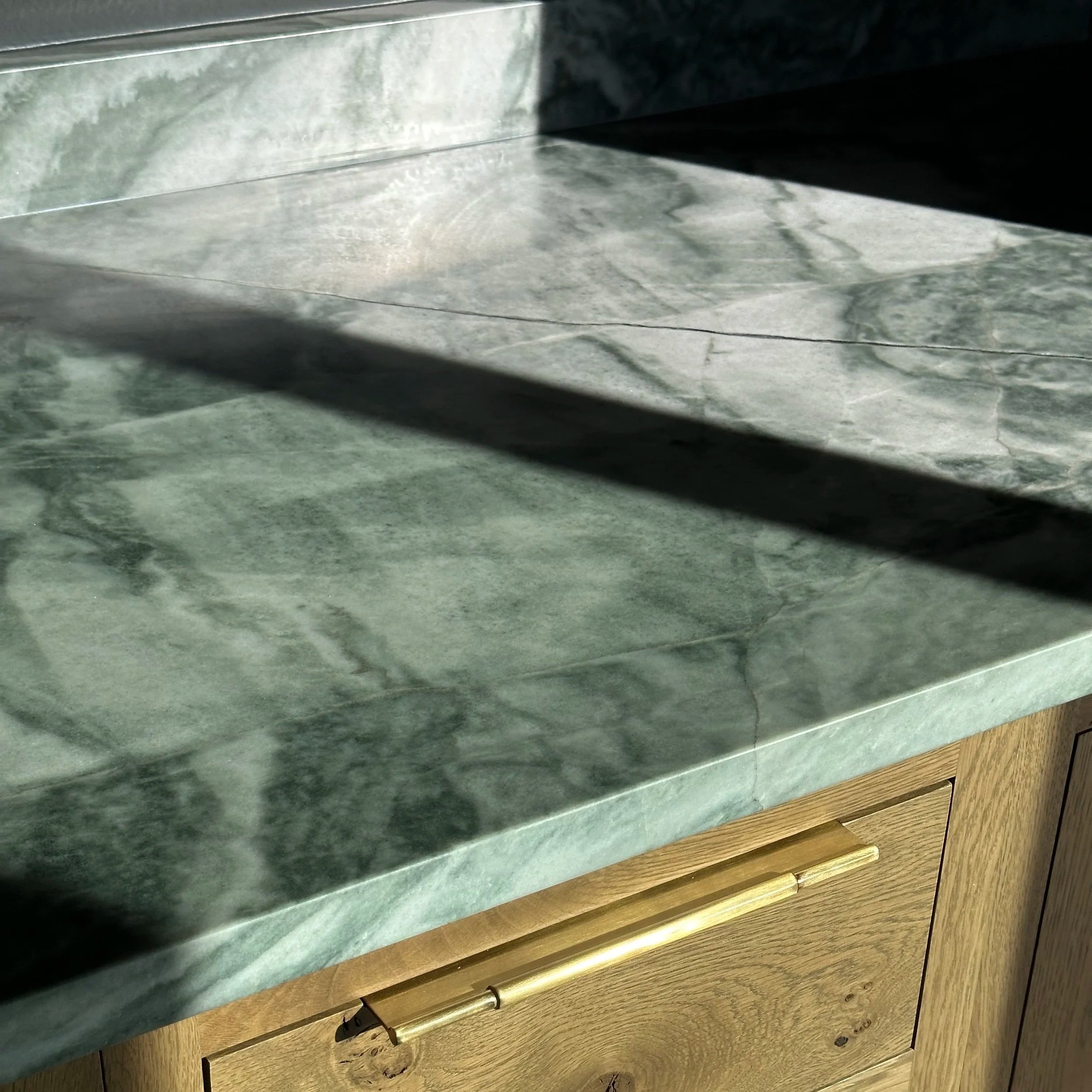 Various types of stone and wood cabinet or countertop surfaces stacked in layers.