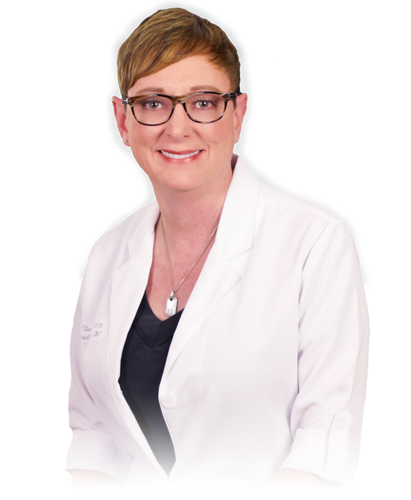 A woman with short light brown hair, glasses, wearing a white medical coat and a necklace, smiling at the camera