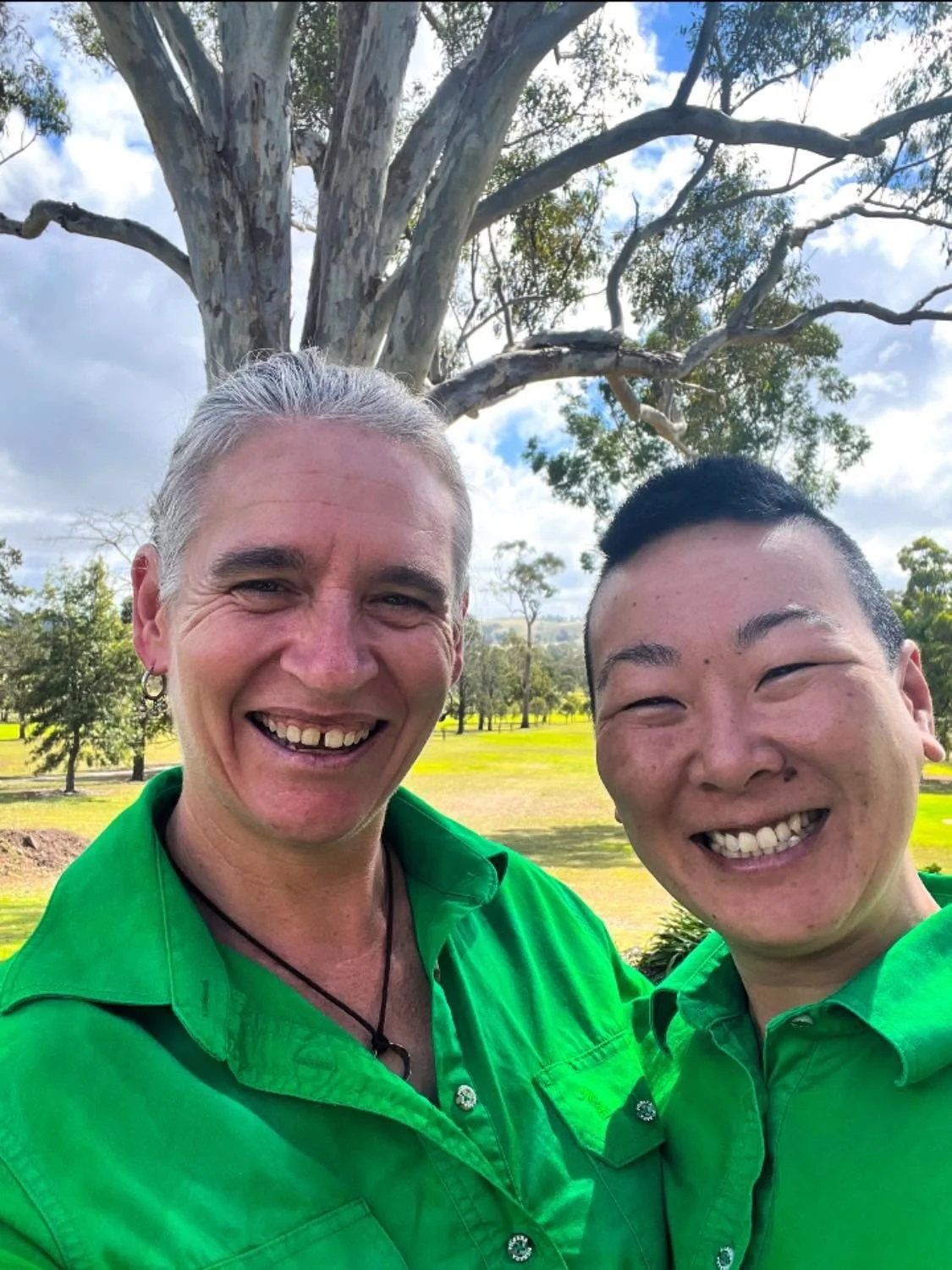 Kat and Vanessa, the Chef s and owners of On the Green Restaurant taking a selfie outdoors in front of a large tree and green park.