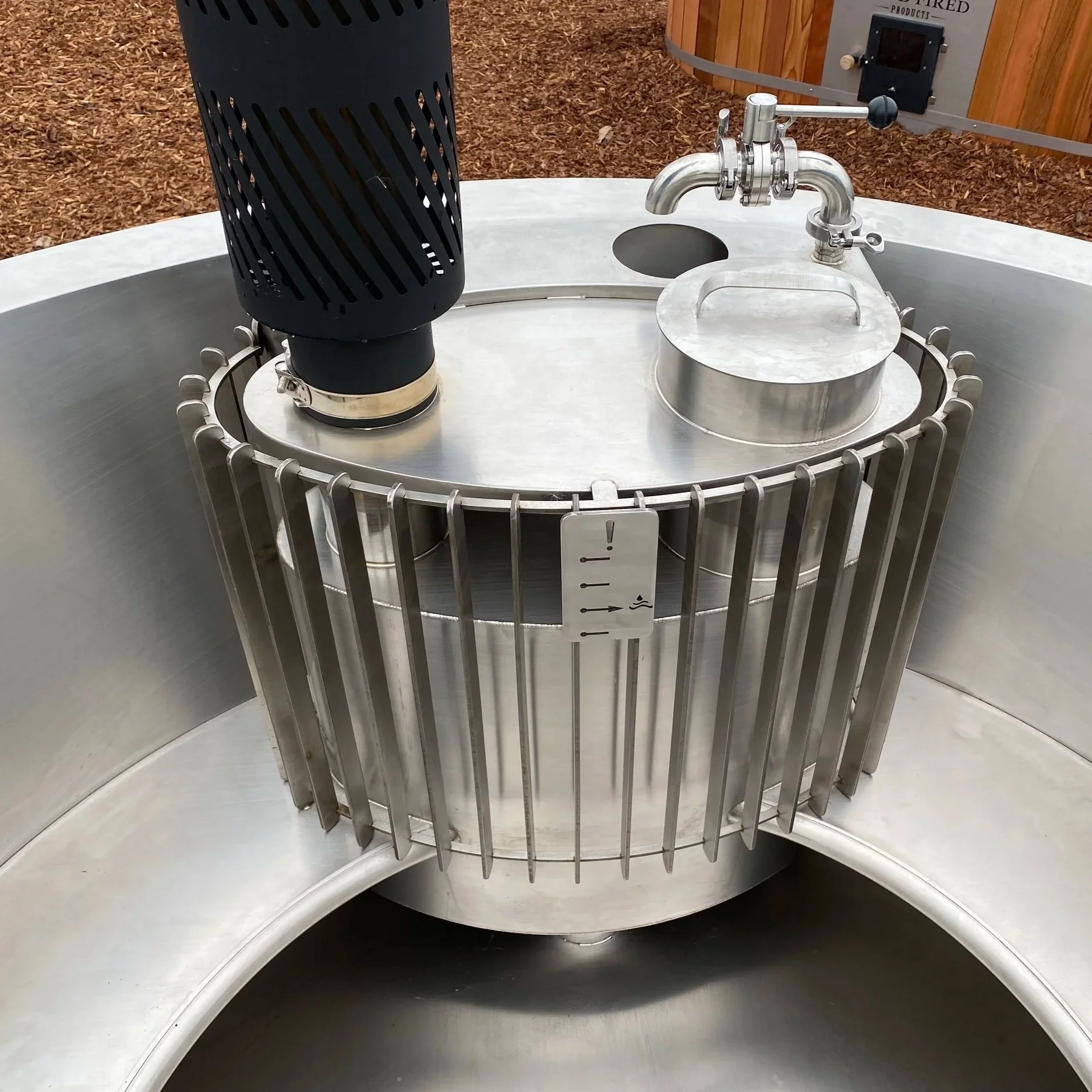 A stainless steel heater chamber and flue in a stainless steel wood fired hot tub