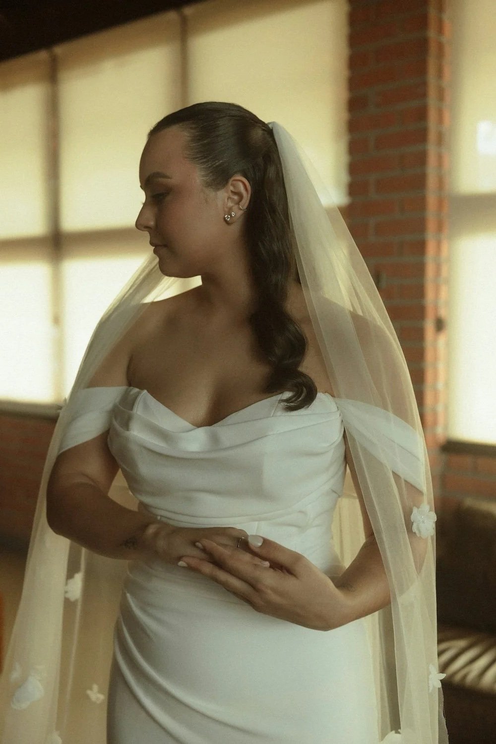 A woman with gorgeous hair and makeup gazing before her ceremony.