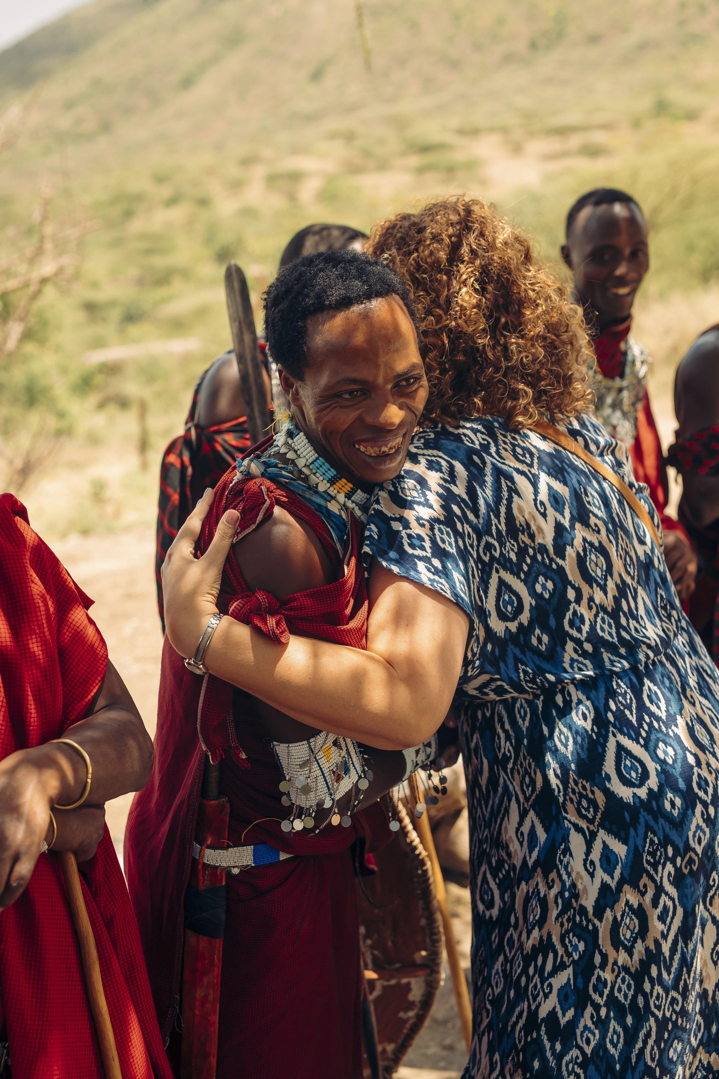 Smiling indigenous women in traditional attire during a cultural event outdoors.