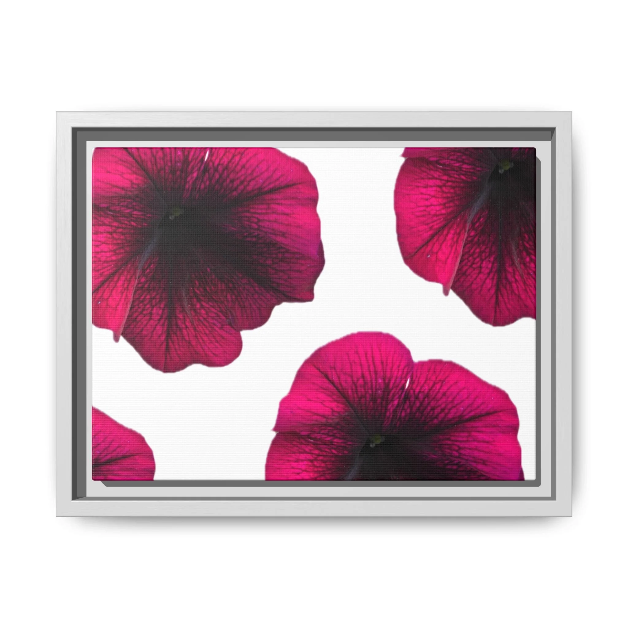 Close-up of a digital screen displaying pink and black flower petals in a grid pattern, framed by a white wooden frame