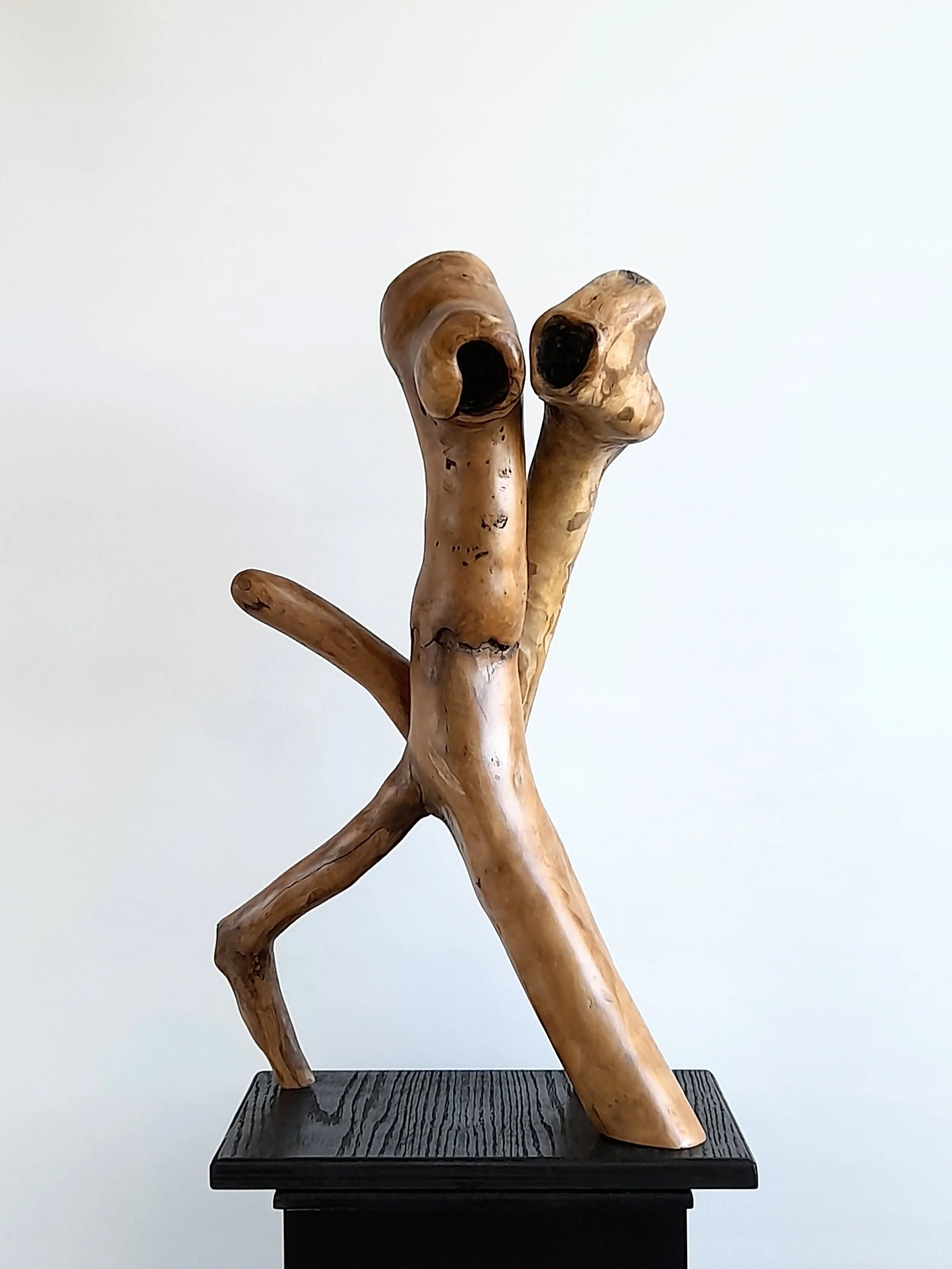 Hand carved wooden sculpture Bound as One on black plinth by Ole Jensen