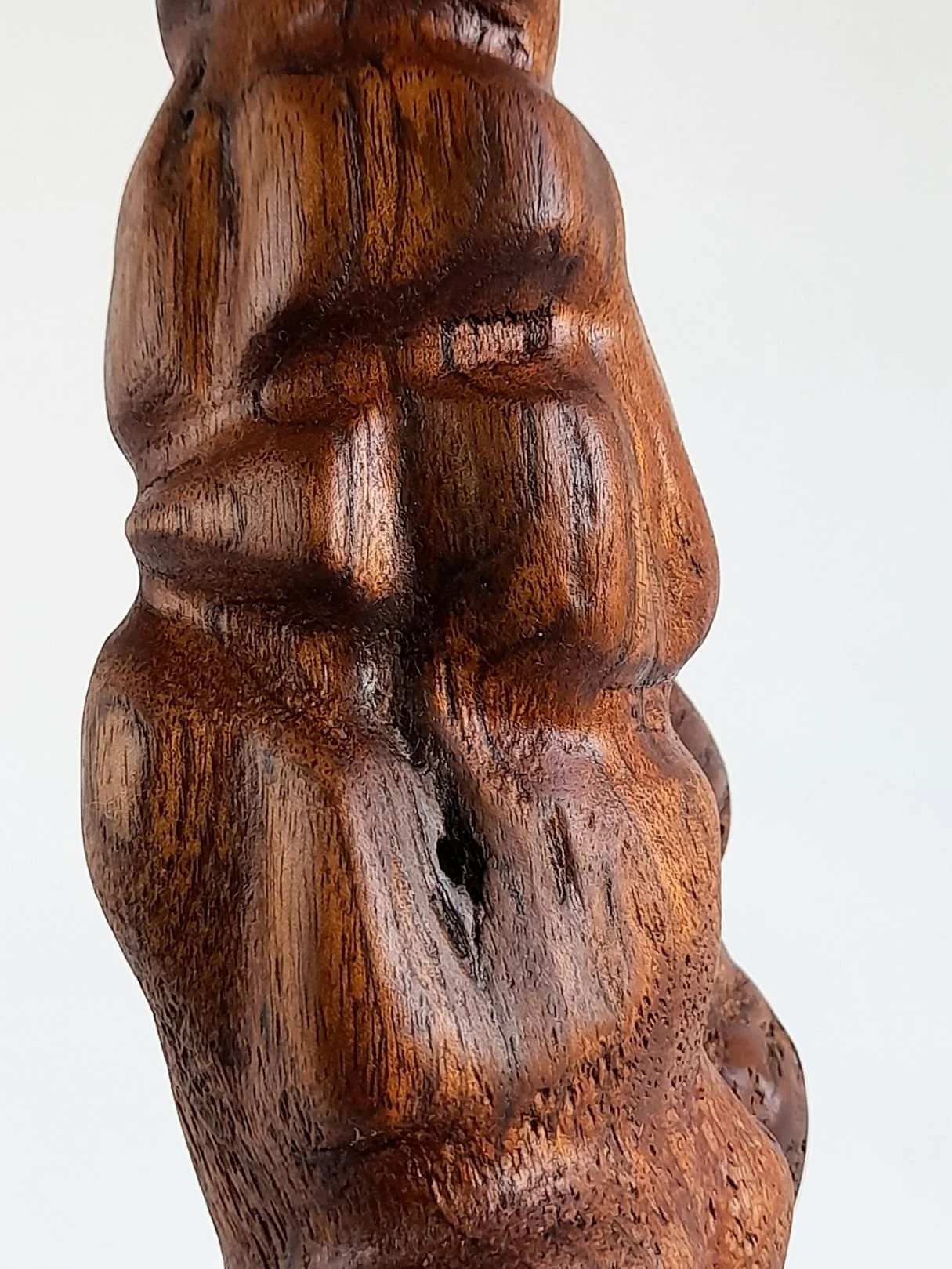 Close-up view of Adoration sculpture showing the gentle hand-carved contours, smooth satin finish, and flowing wood grain.