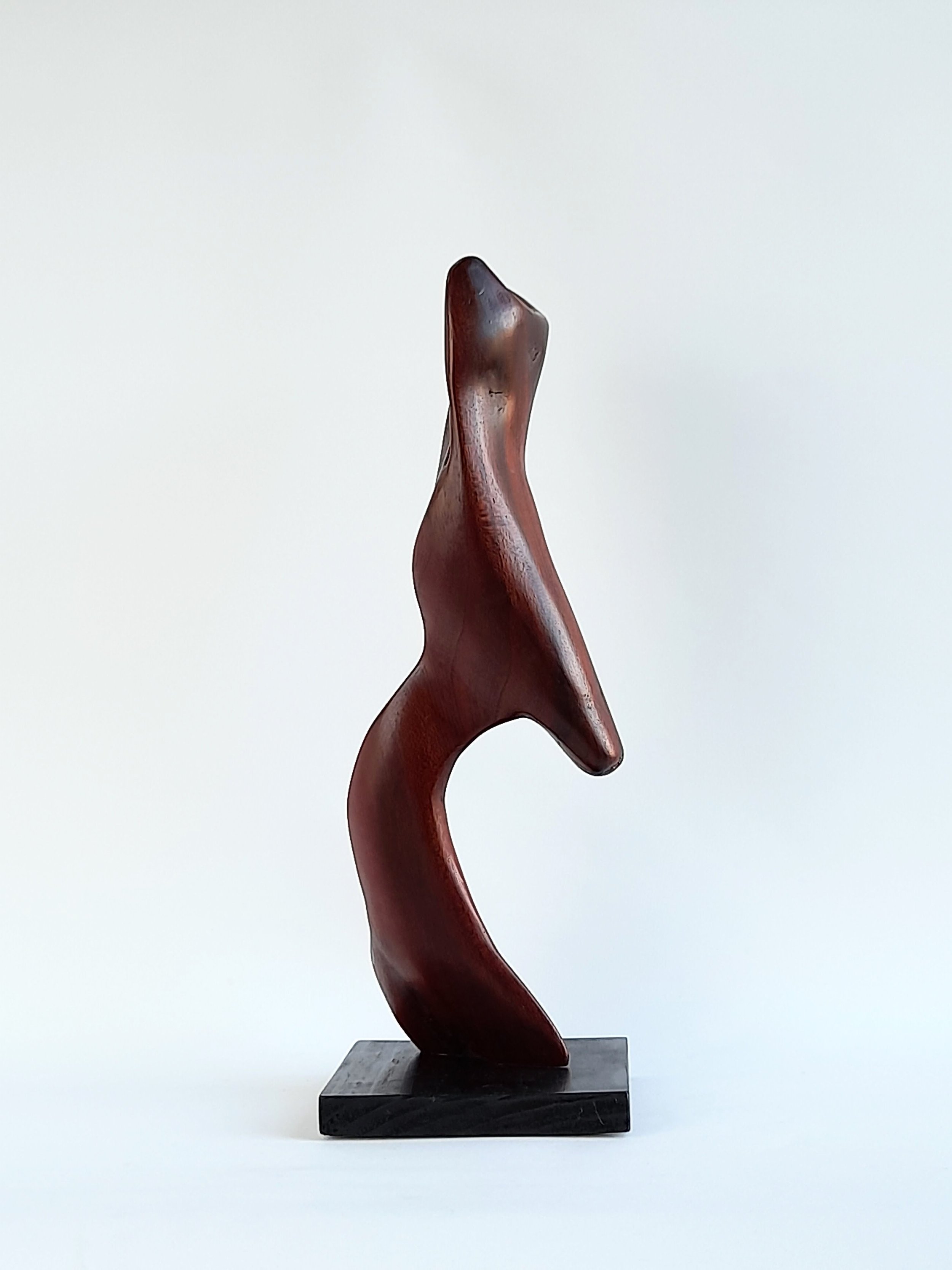 Balanced wooden sculpture titled Poise, featuring delicate sweeping curves and a smooth, hand-finished polish.