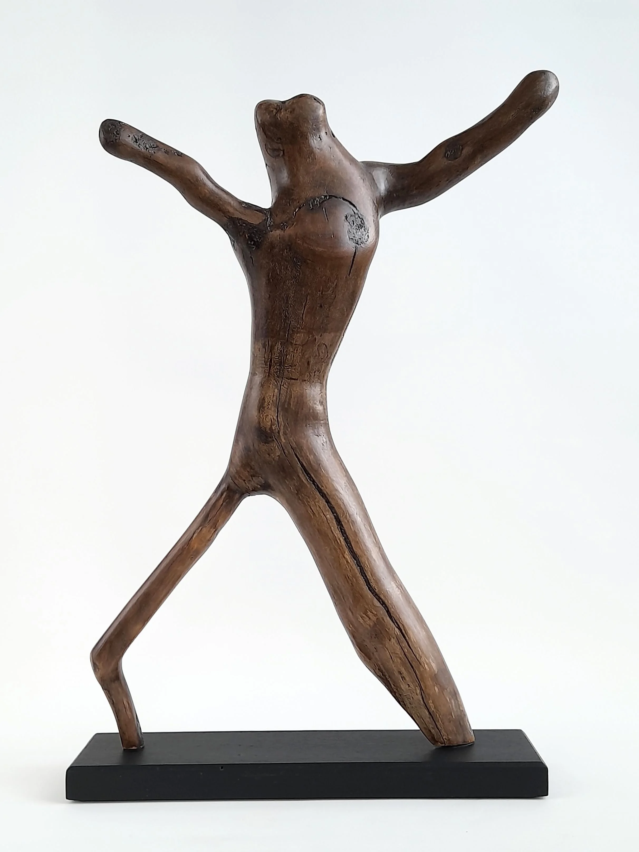Side view of Alien Dancer timber sculpture showing contrasting leg dimensions and dark wax finish on She-Oak grain.