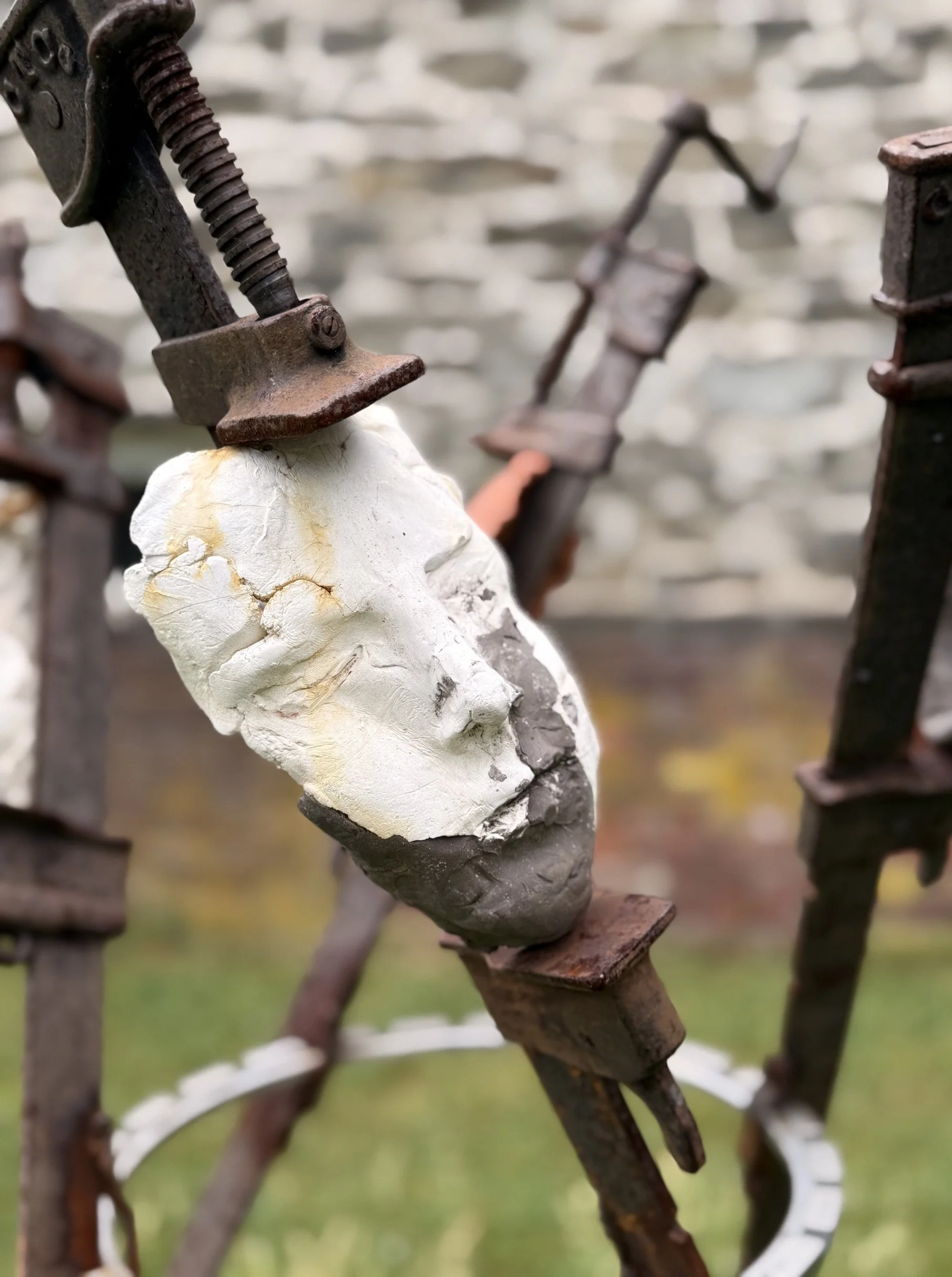 The Tribunal, outdoor sculpture by New York sculptor Aleksandra Scepanovic featuring reclaimed industrial steel and fired clay figures. Clay face closeup