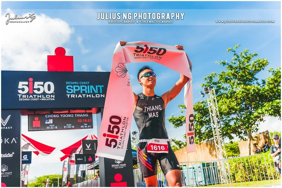 Finisher celebrating with the race towel after completing the Desaru Coast Sprint Triathlon in Johor.