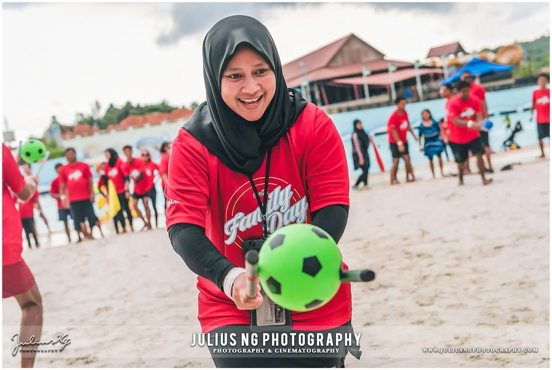 Coca-Cola employees participating in beach games during a corporate family day and team building event at Adventure Waterpark Desaru Coast, Johor.