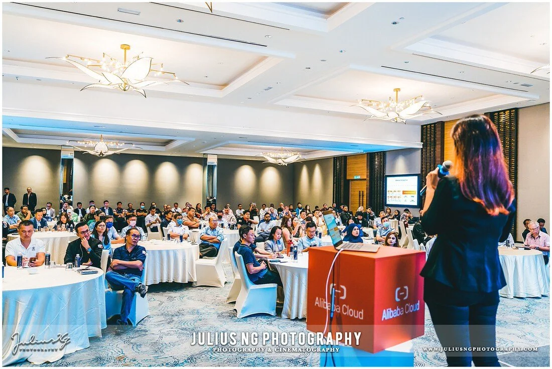 Corporate seminar photography capturing keynote presentation at Alibaba Cloud business conference in Johor Bahru.