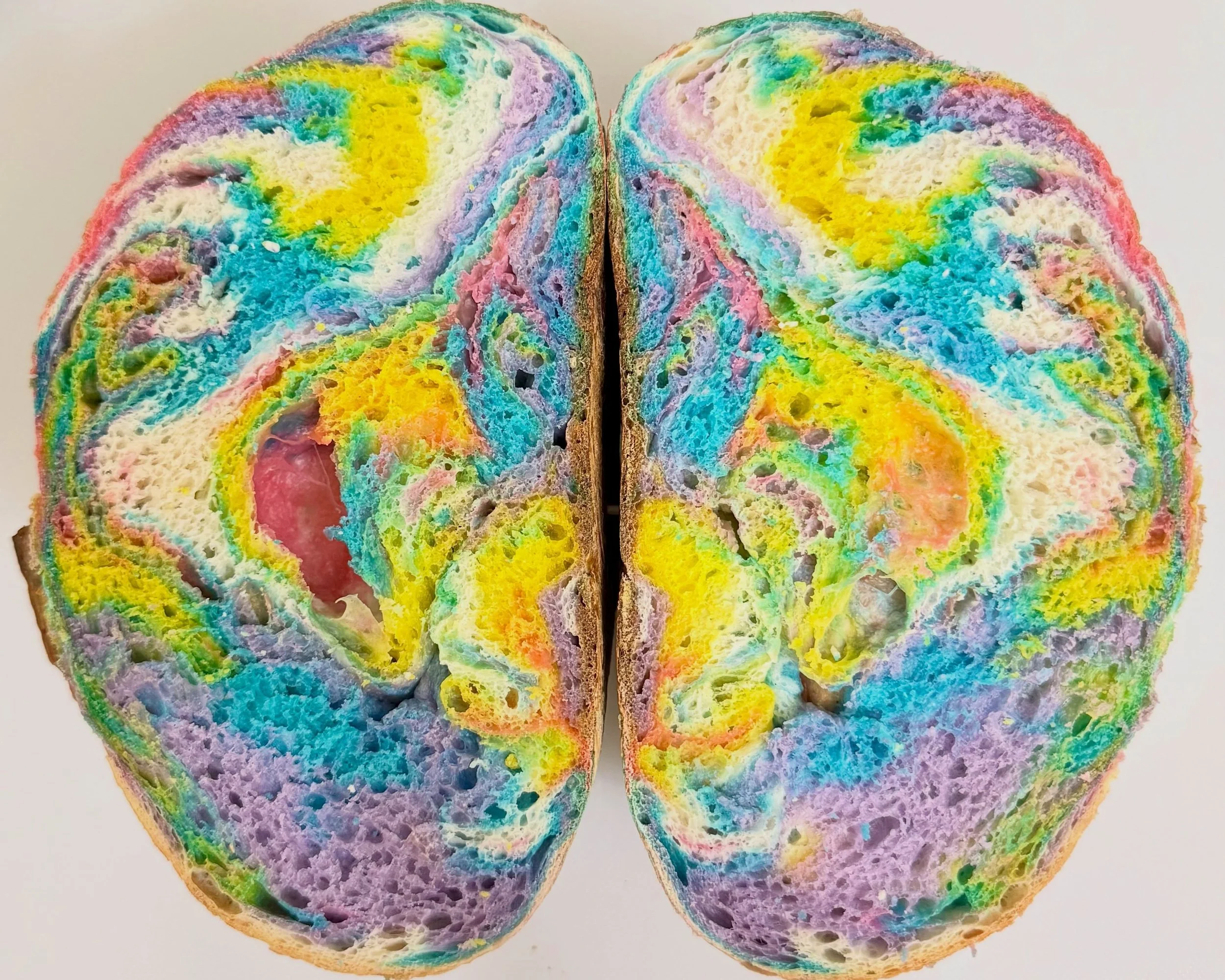 Tie-dye loaf! She had a funky bubble on the left half but we still love her! What do you see? #sourdough #sourdoughbread #tiedye #baking #art