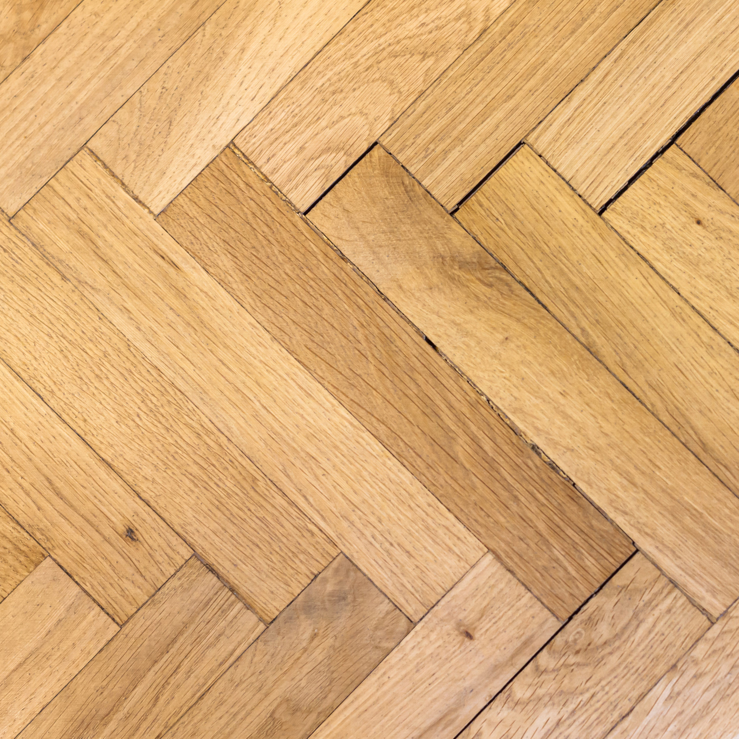 Nahaufnahme eines Holzfußbodens mit diagonalen Dielen.